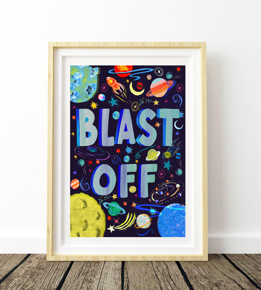 Framed children's poster with 'BLAST OFF' text and space-themed graphics on a white wall.