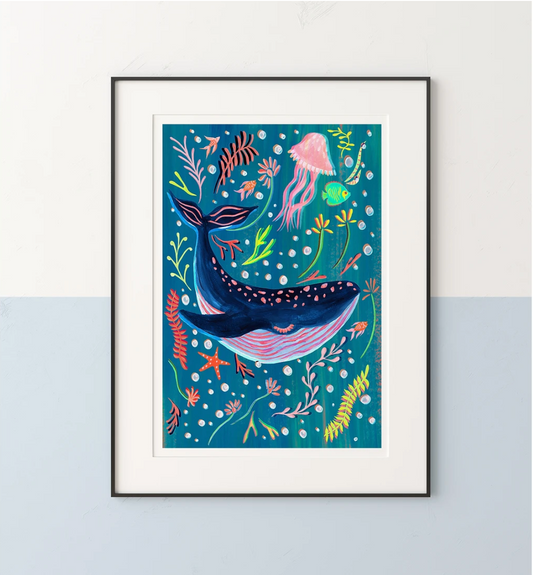Framed artwork of a whale surrounded by sea creatures on a blue background