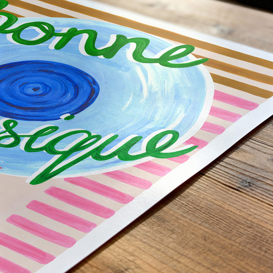 Colorful poster with 'bonne musique' text on a wooden surface