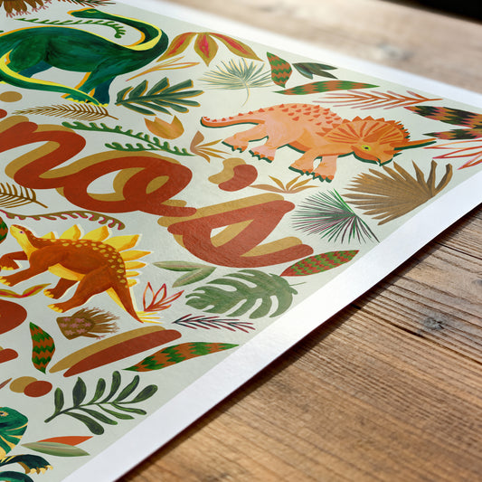 Colorful dinosaur illustration on a paper with 'hello' text, placed on a wooden surface.