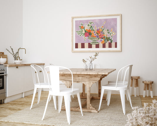 Dining room with wooden table and white chairs, framed artwork on the wall.