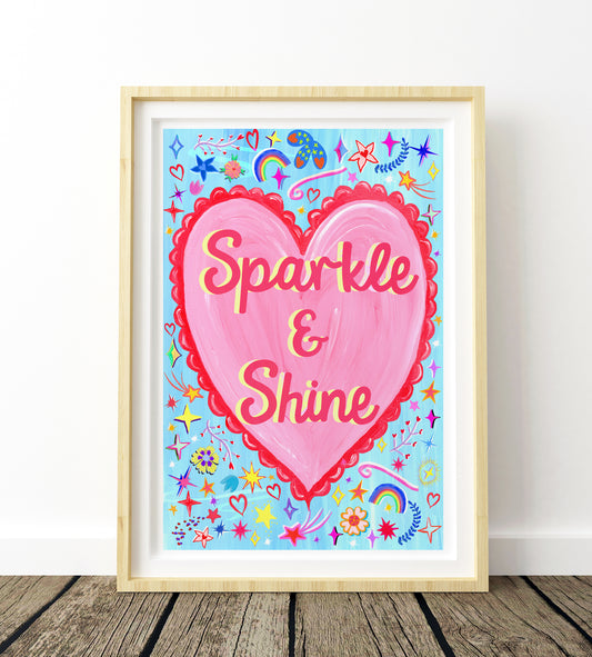 Framed artwork with a pink heart and 'Sparkle & Shine' text on a colorful background.