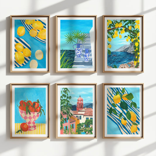 Set of six framed artworks featuring colorful scenes with lemons, tomatoes, and architectural elements on a white wall.