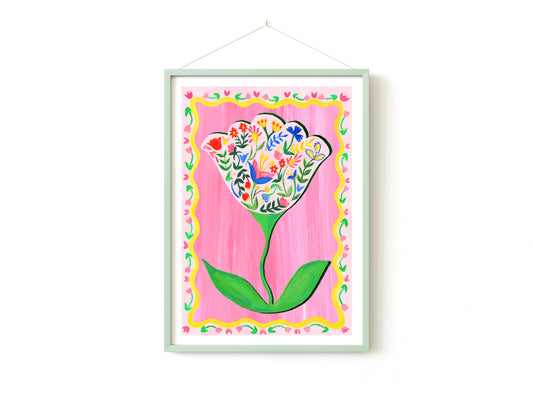 Framed artwork of a colorful flower design on a pink background