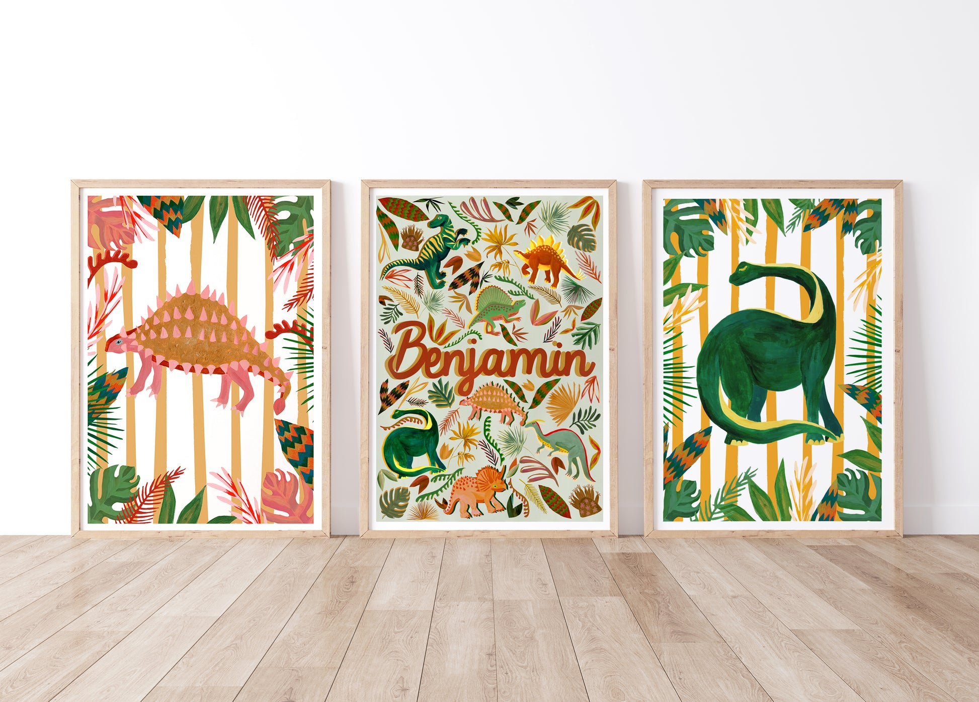 Three framed dinosaur-themed prints on a wall with a wooden floor.