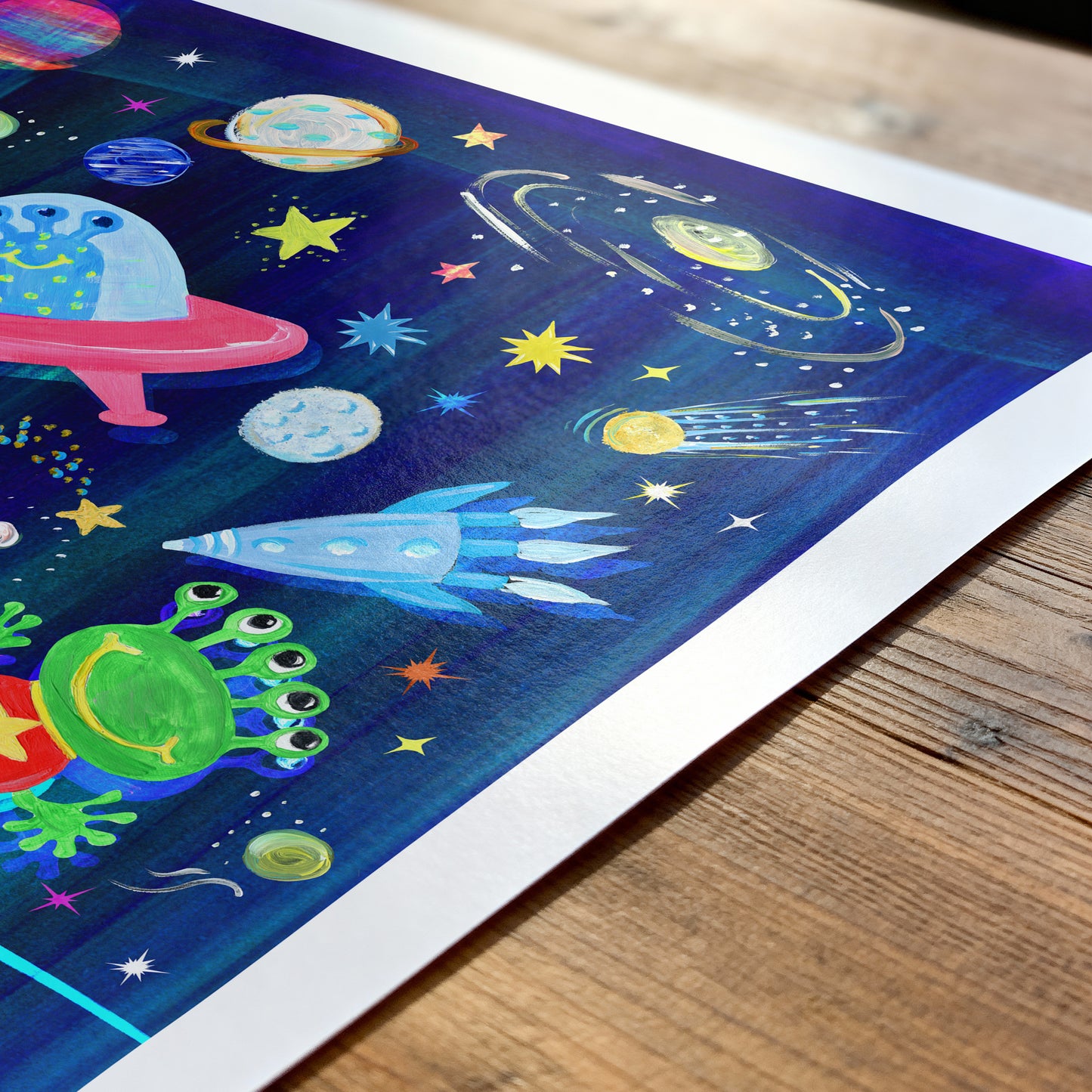 Colorful space-themed artwork on a wooden surface