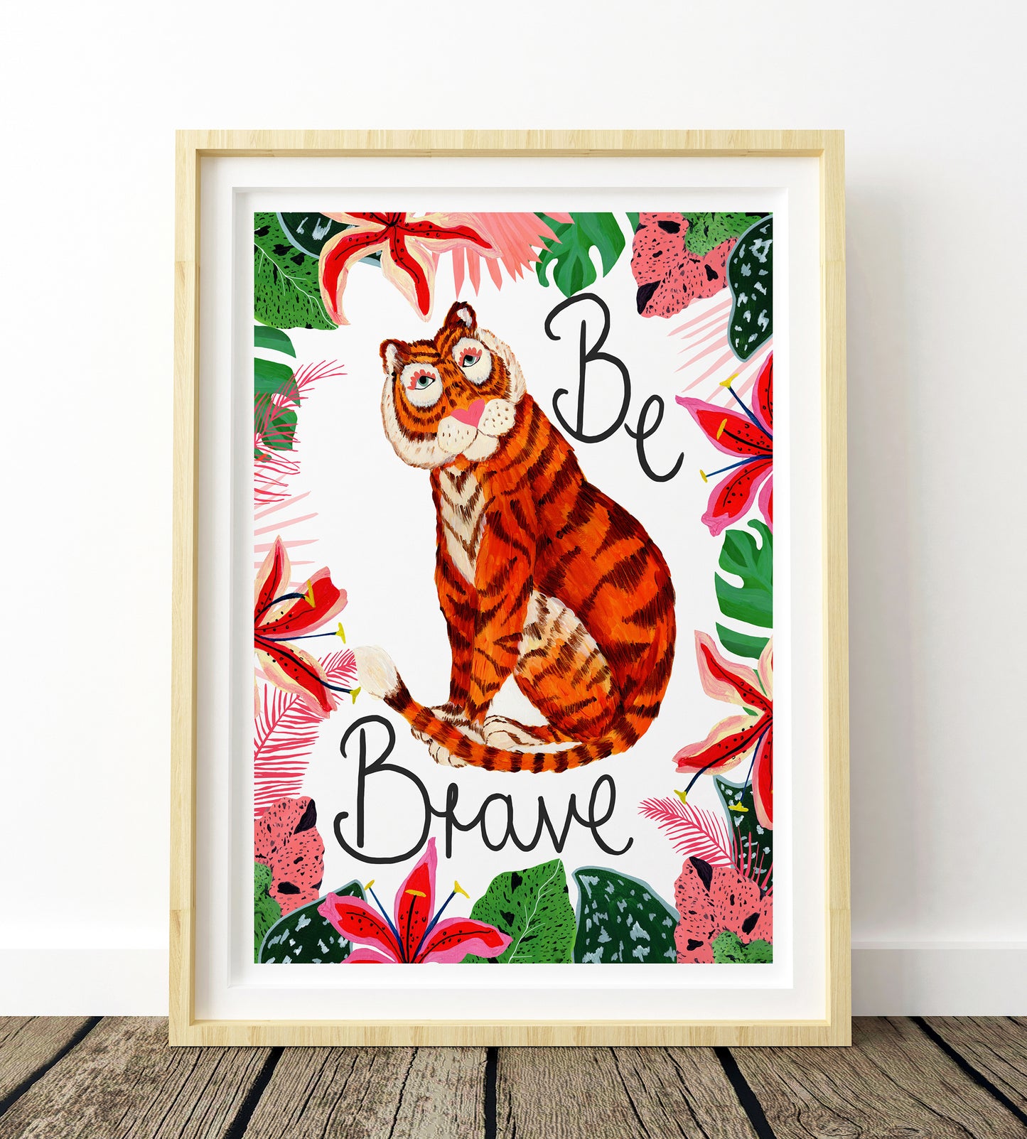 Framed artwork with a tiger illustration and 'Be Brave' text on a floral background.