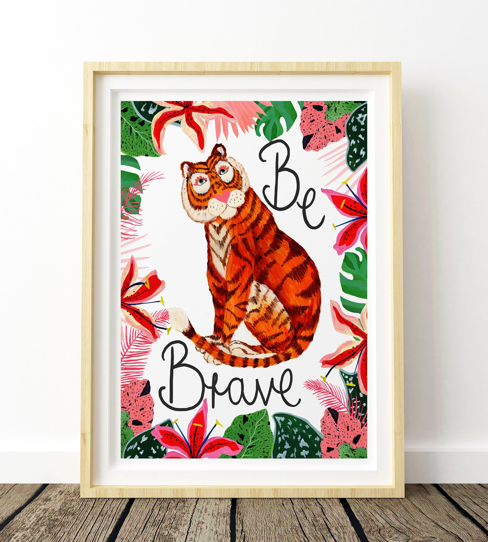 Framed artwork with a tiger illustration and 'Be Brave' text on a floral background.