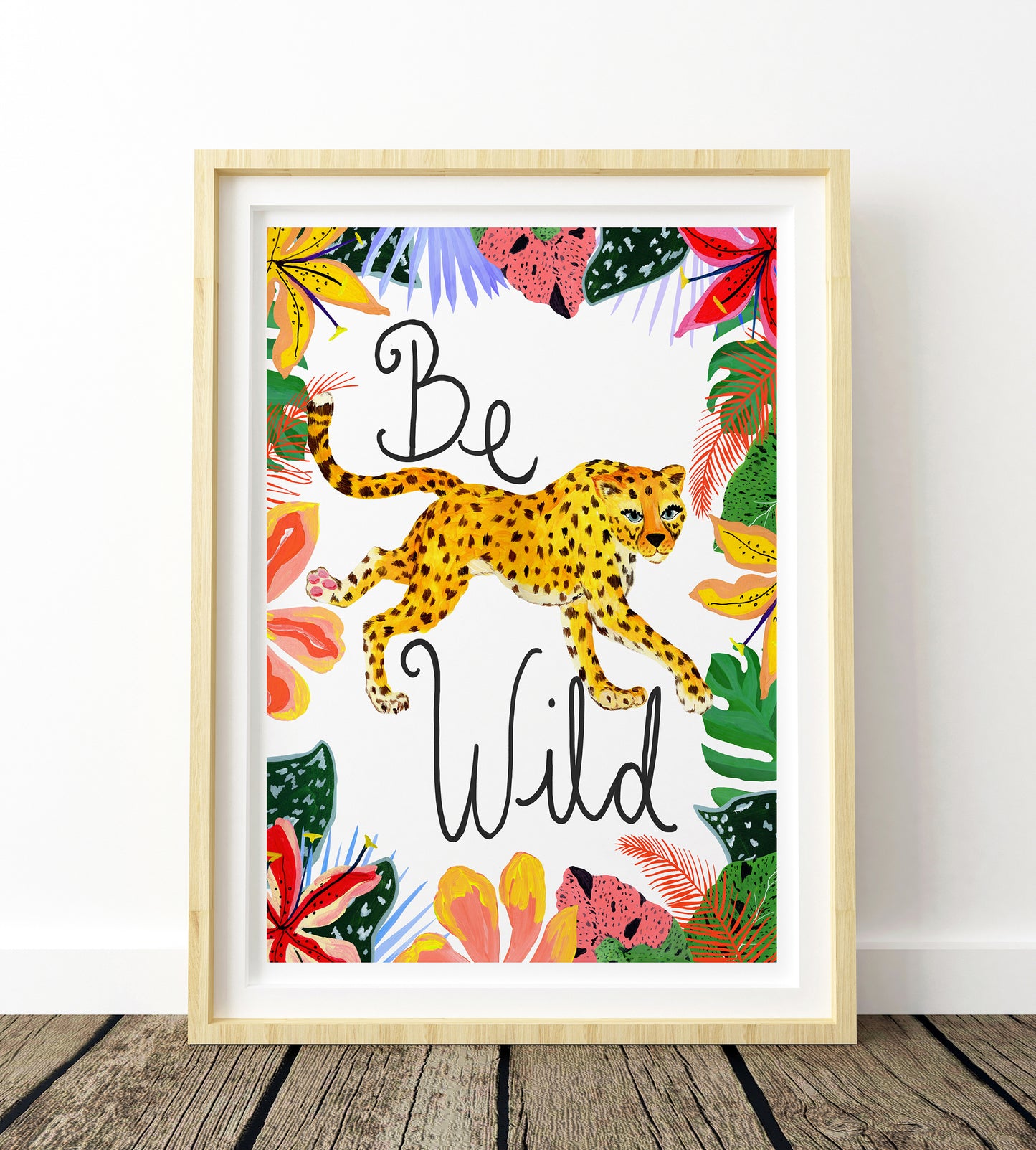Framed artwork with a leopard and tropical leaves on a white background