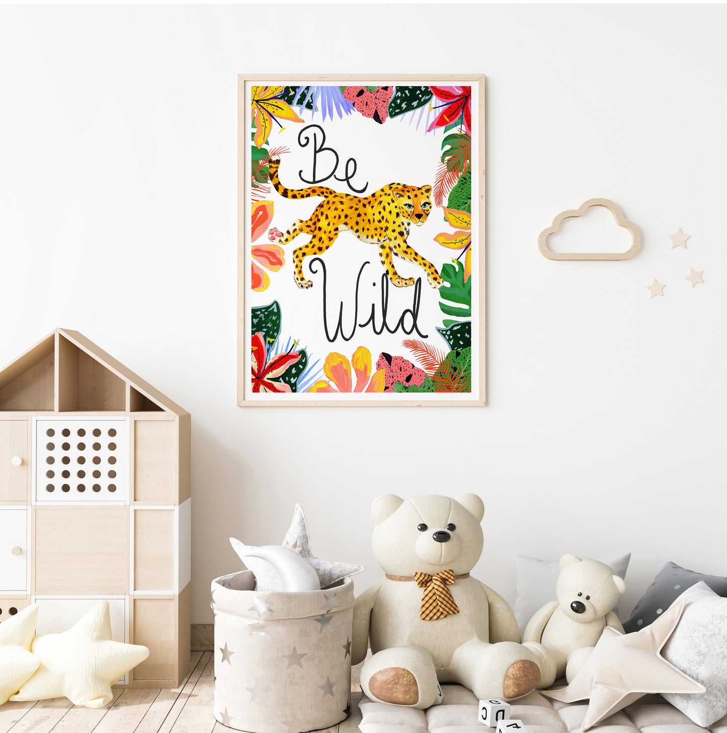 Framed artwork with 'Be Wild' text and a leopard illustration in a child's room with toys and storage bins.