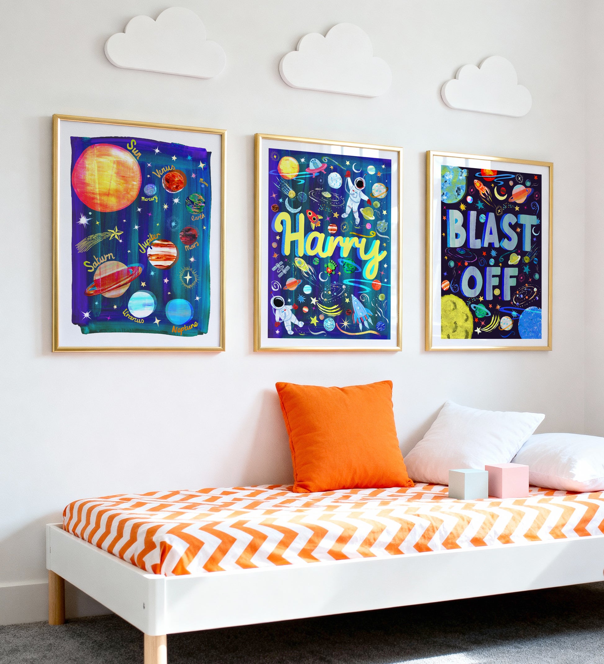 Children's bedroom with space-themed wall art and a bed with orange and white bedding.