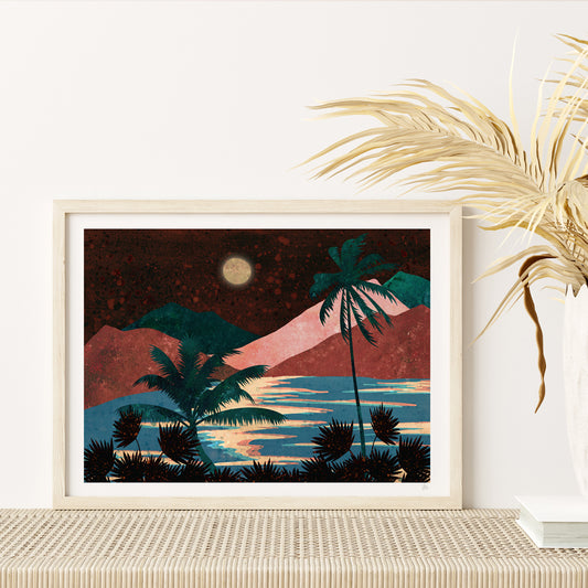Framed artwork of a tropical landscape with palm trees and mountains on a white wall.