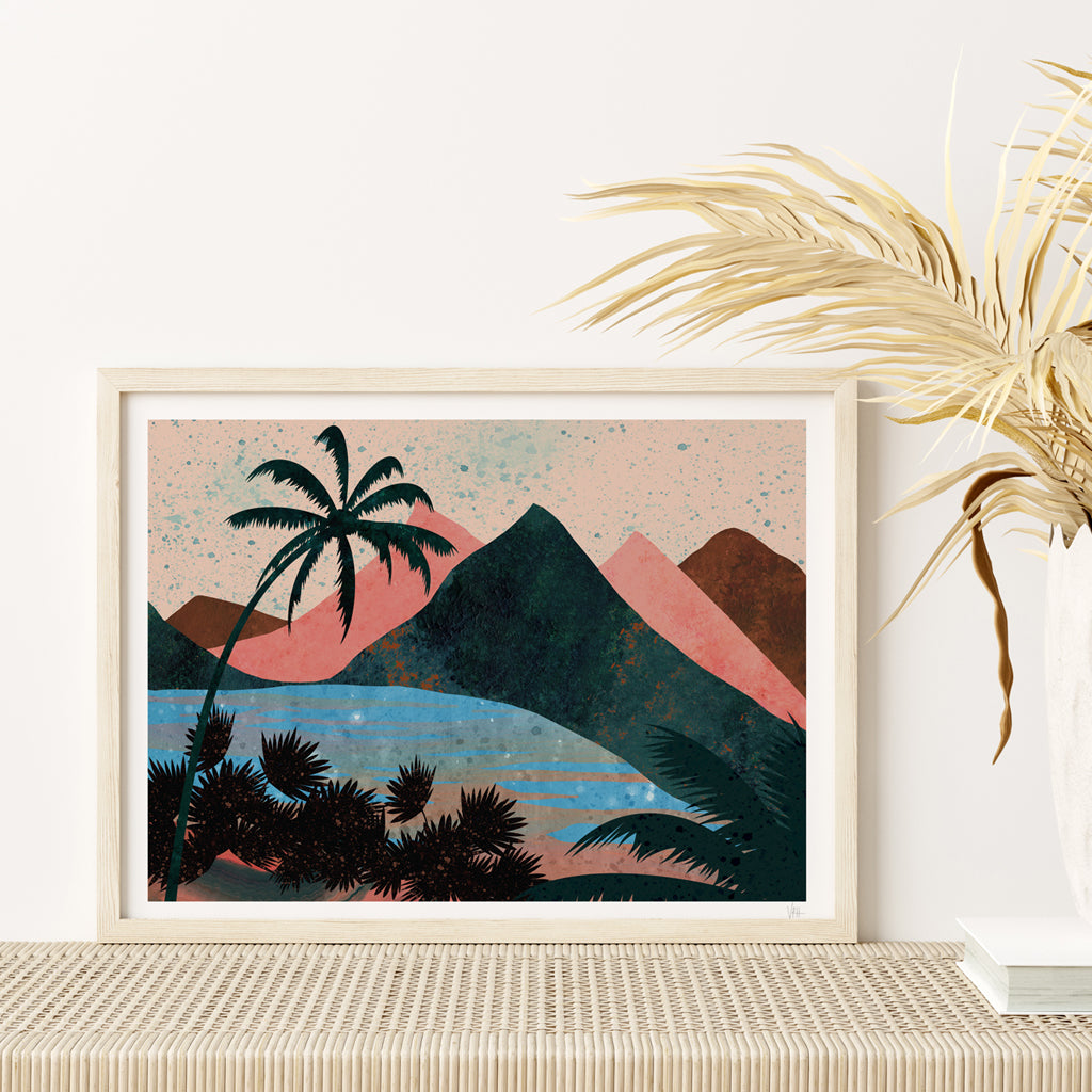 Framed artwork of a tropical landscape with palm trees and mountains on a white wall.