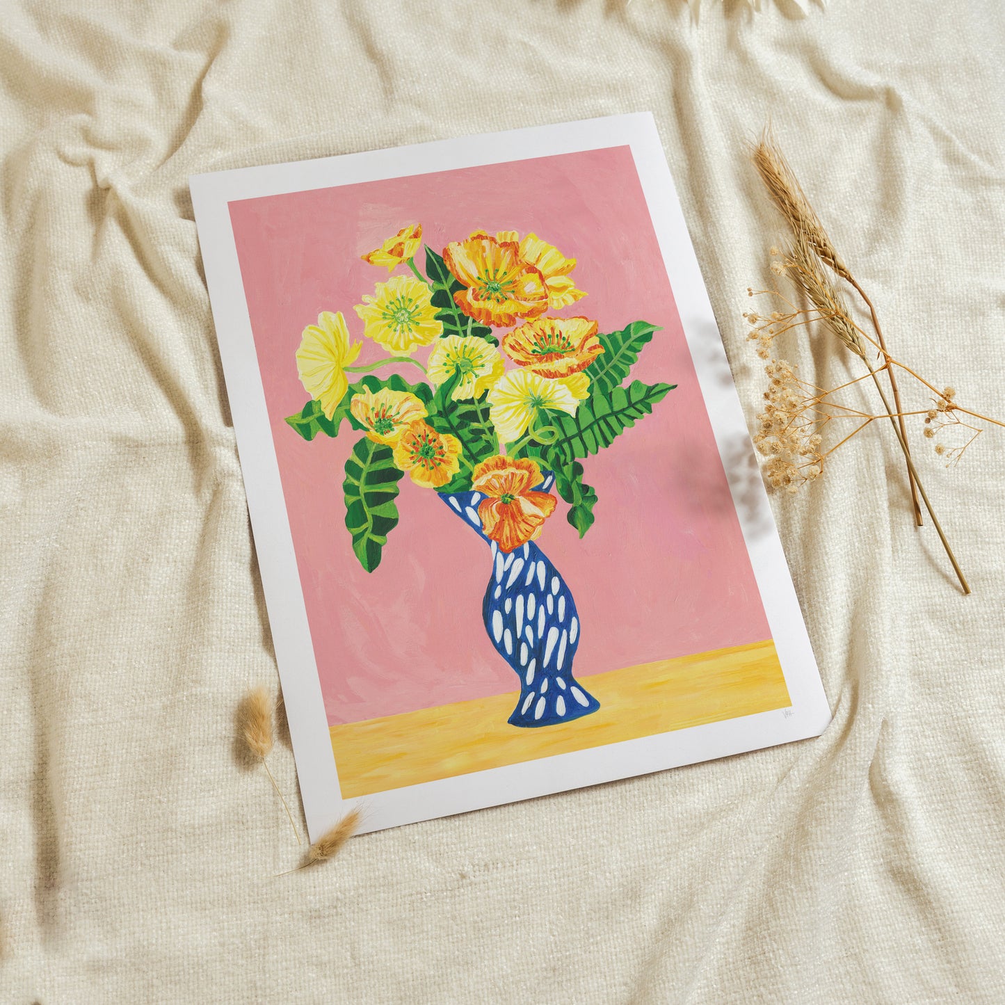 Card with a colorful floral design on a pink background, placed on a textured beige surface.