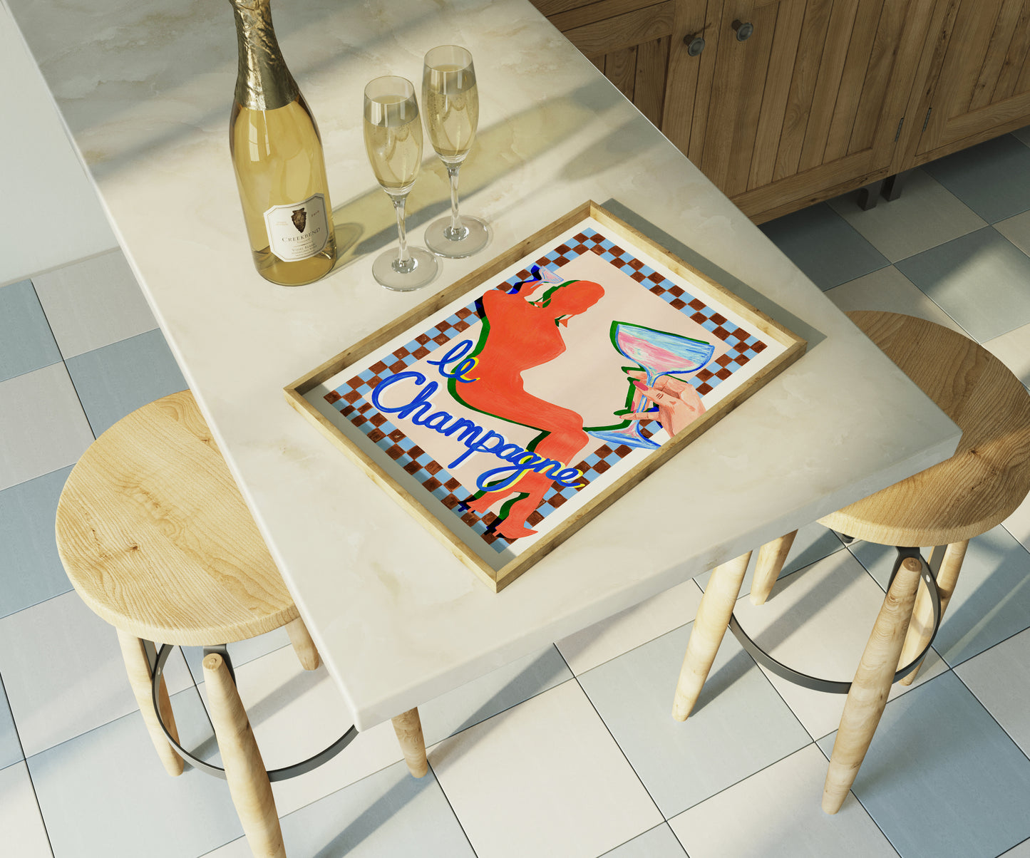 Table with a colorful tray, champagne bottle, and glasses in a kitchen setting.