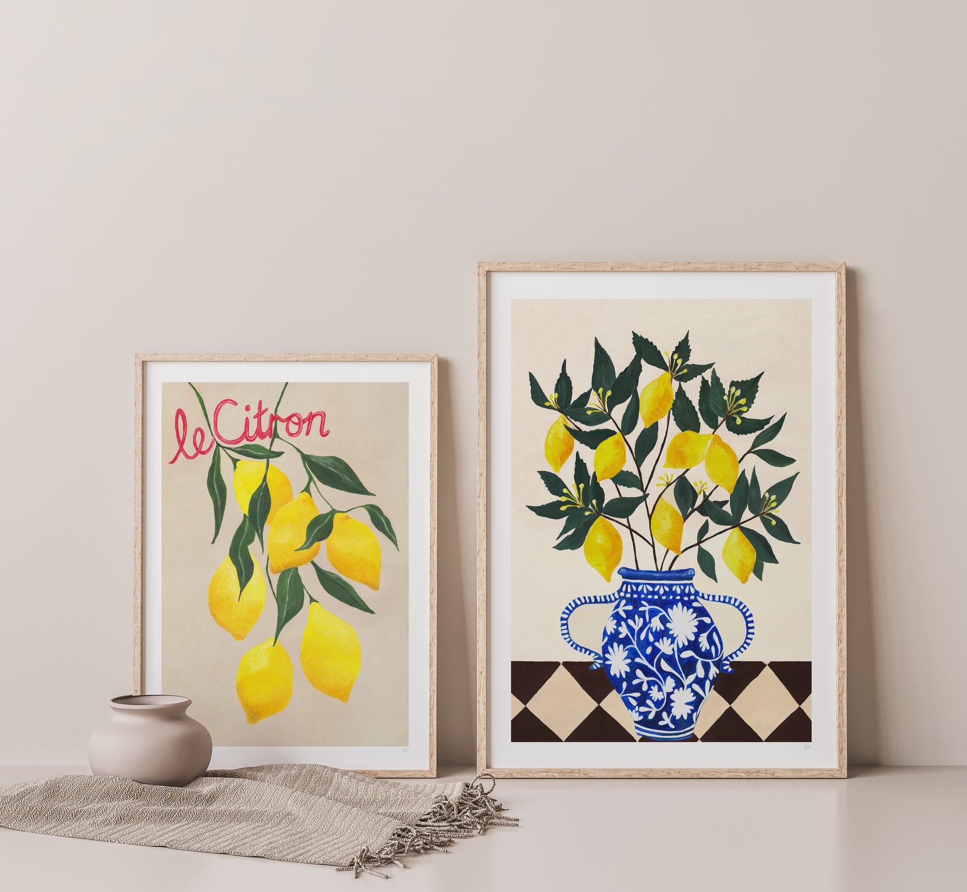 Two framed artworks featuring lemons and a vase on a neutral background