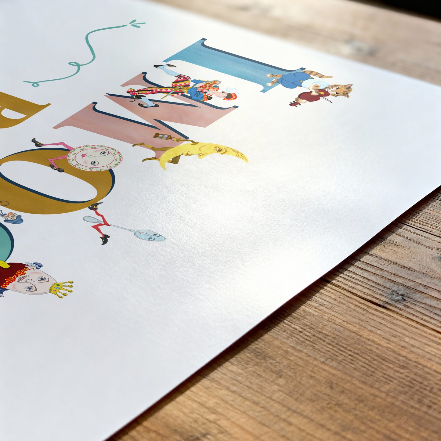Colorful children's name printl on a white sheet of paper with a wooden surface underneath.
