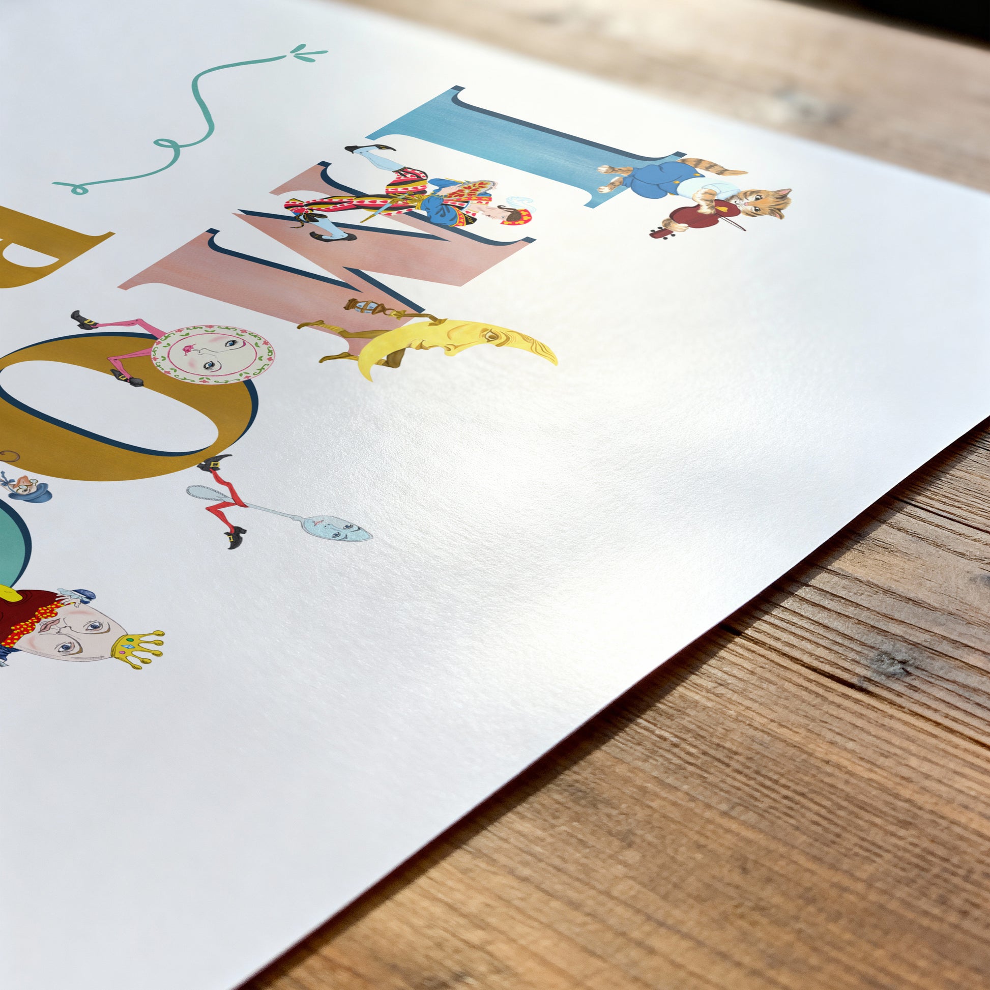 Colorful children's name printl on a white sheet of paper with a wooden surface underneath.