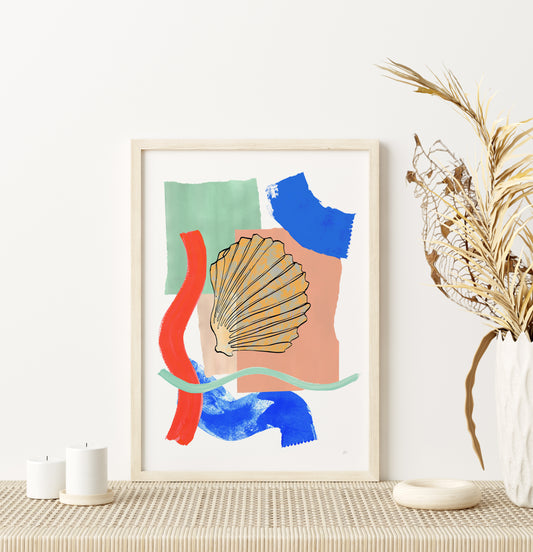 Framed abstract art print with colorful shapes on a wall above a table.