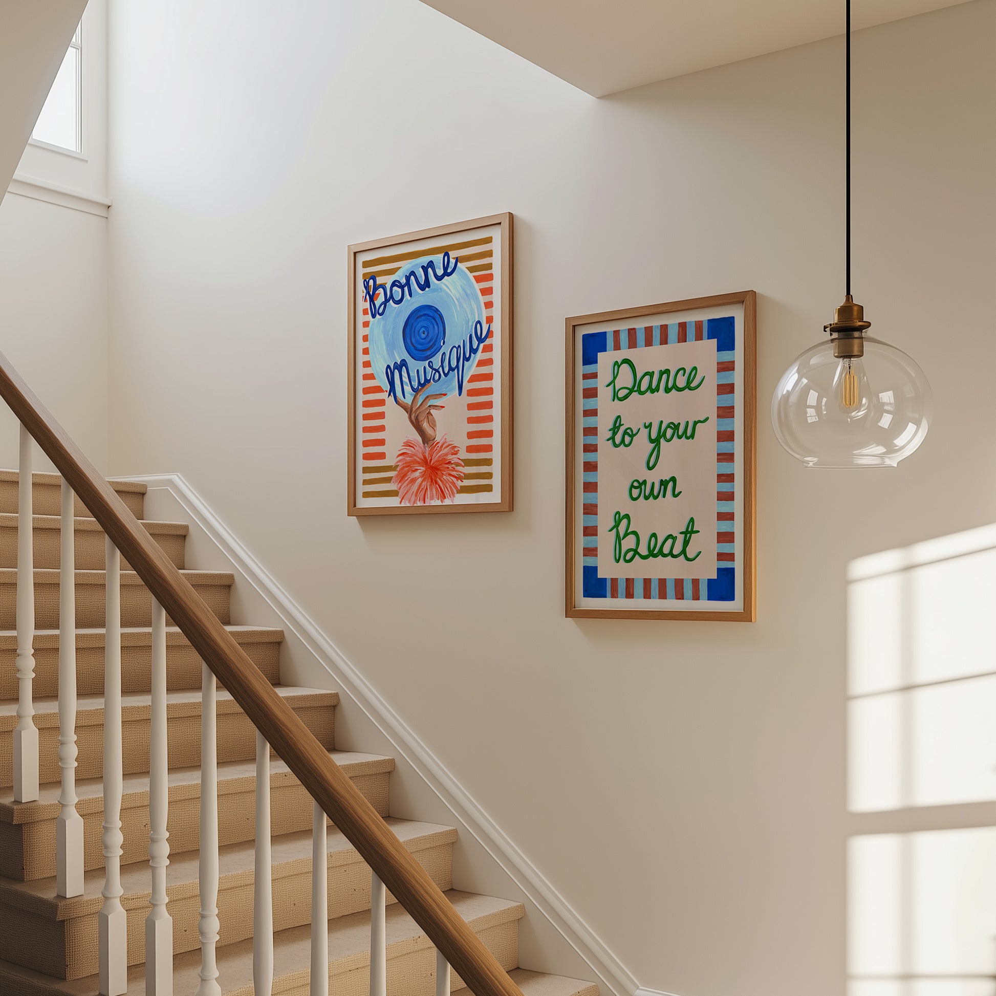 Staircase with framed artwork on a wall, including 'Bonne Musique' and 'Dance to your own Beat' quotes.