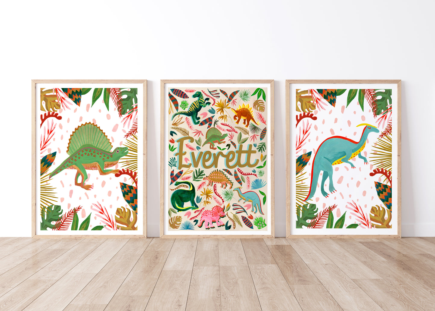Three framed dinosaur-themed artworks on a white wall with wooden floor.