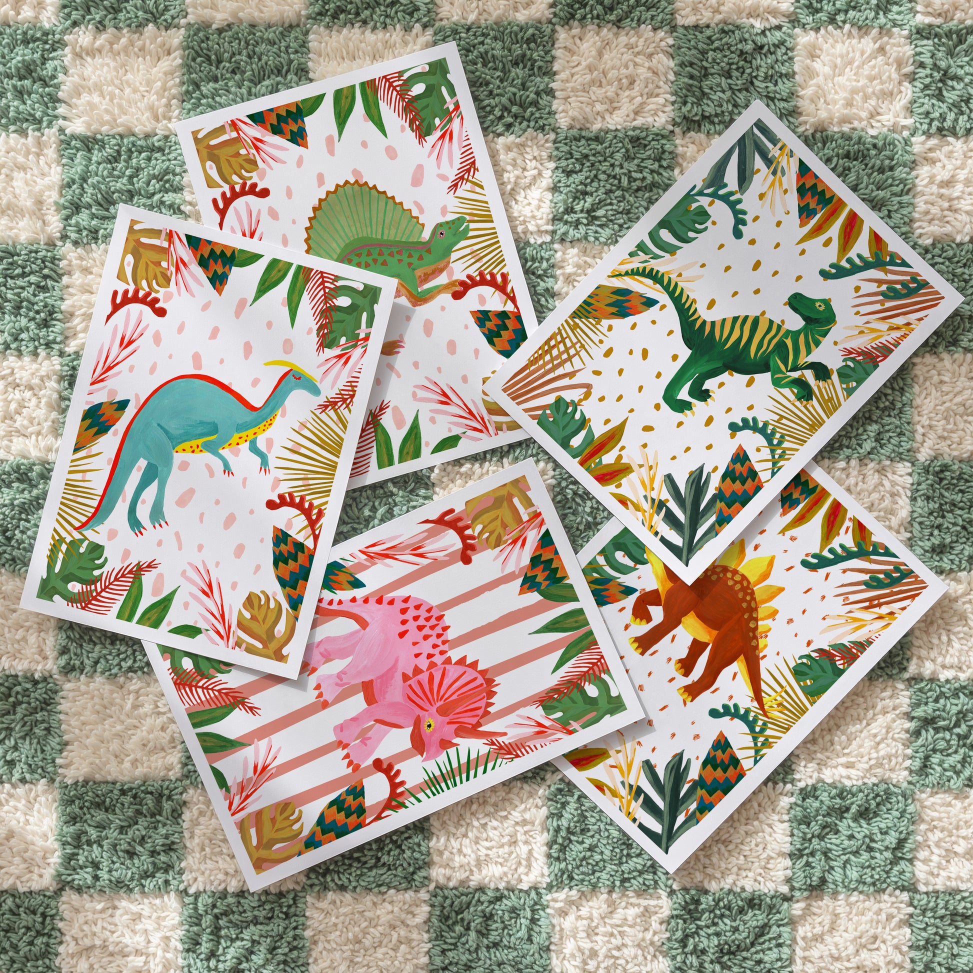 Set of colorful dinosaur cards on a checkered fabric background