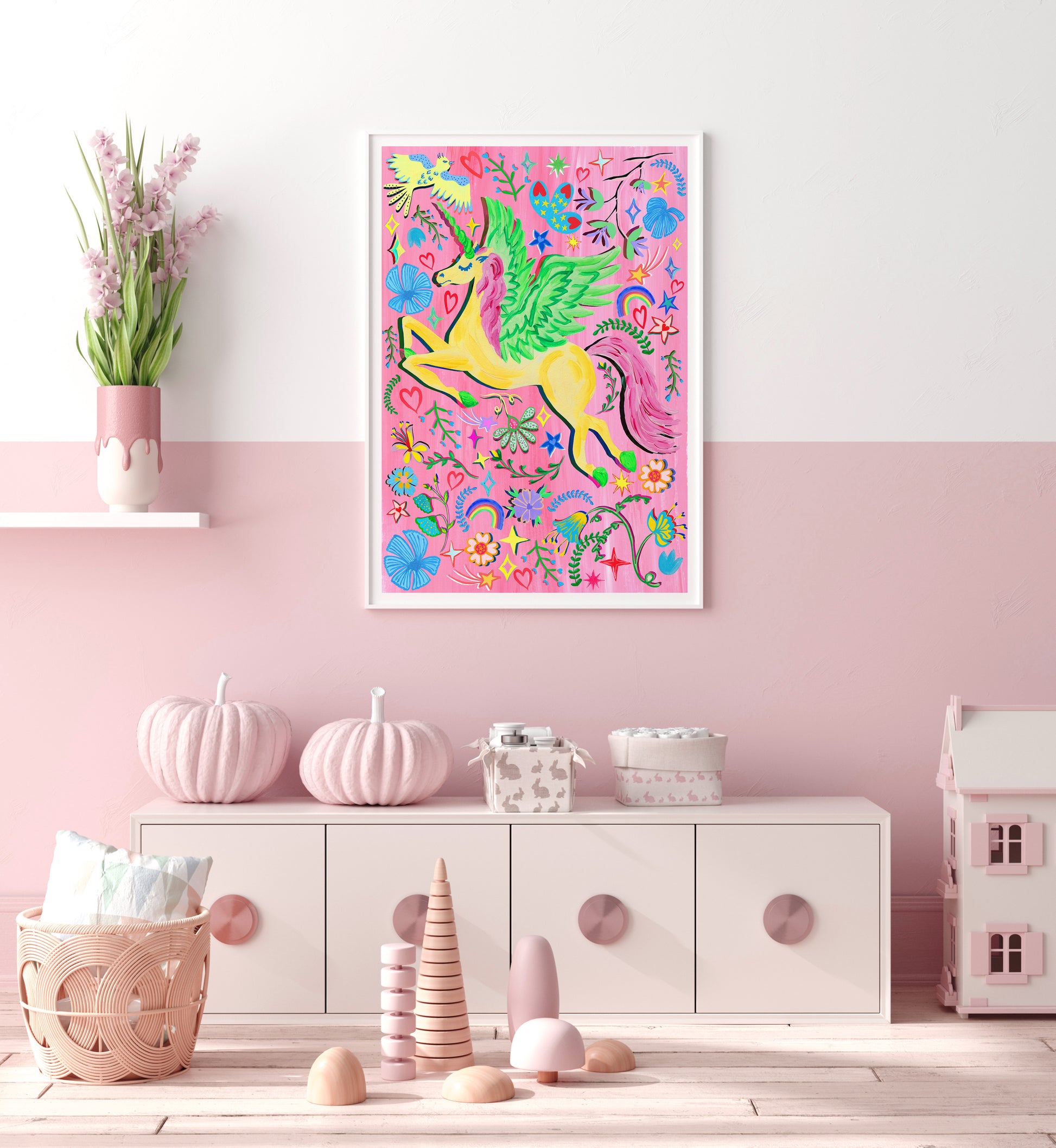 Colorful unicorn illustration on a pink wall with decorative items below.