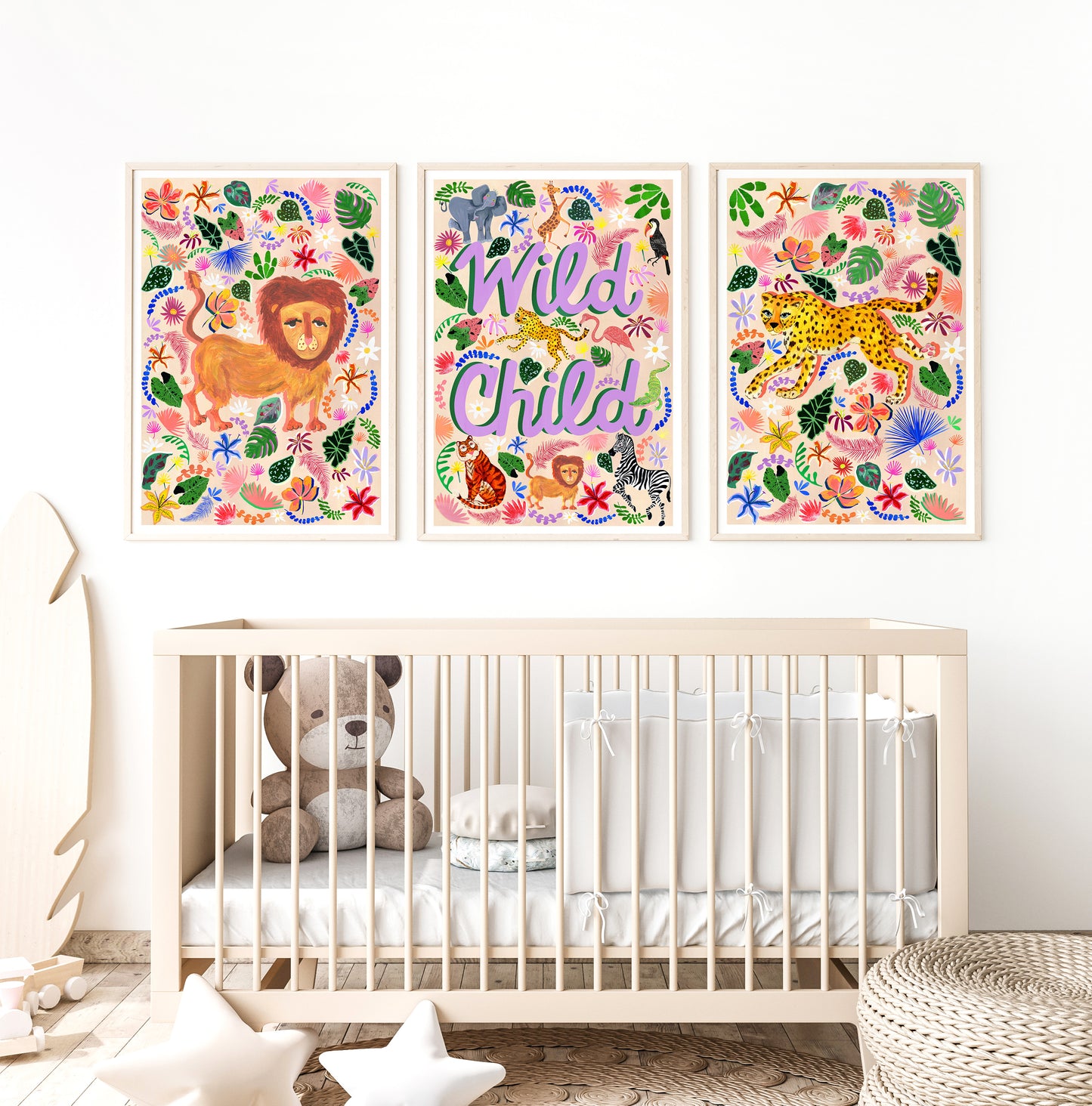 Three colorful animal-themed wall posters above a crib in a nursery.