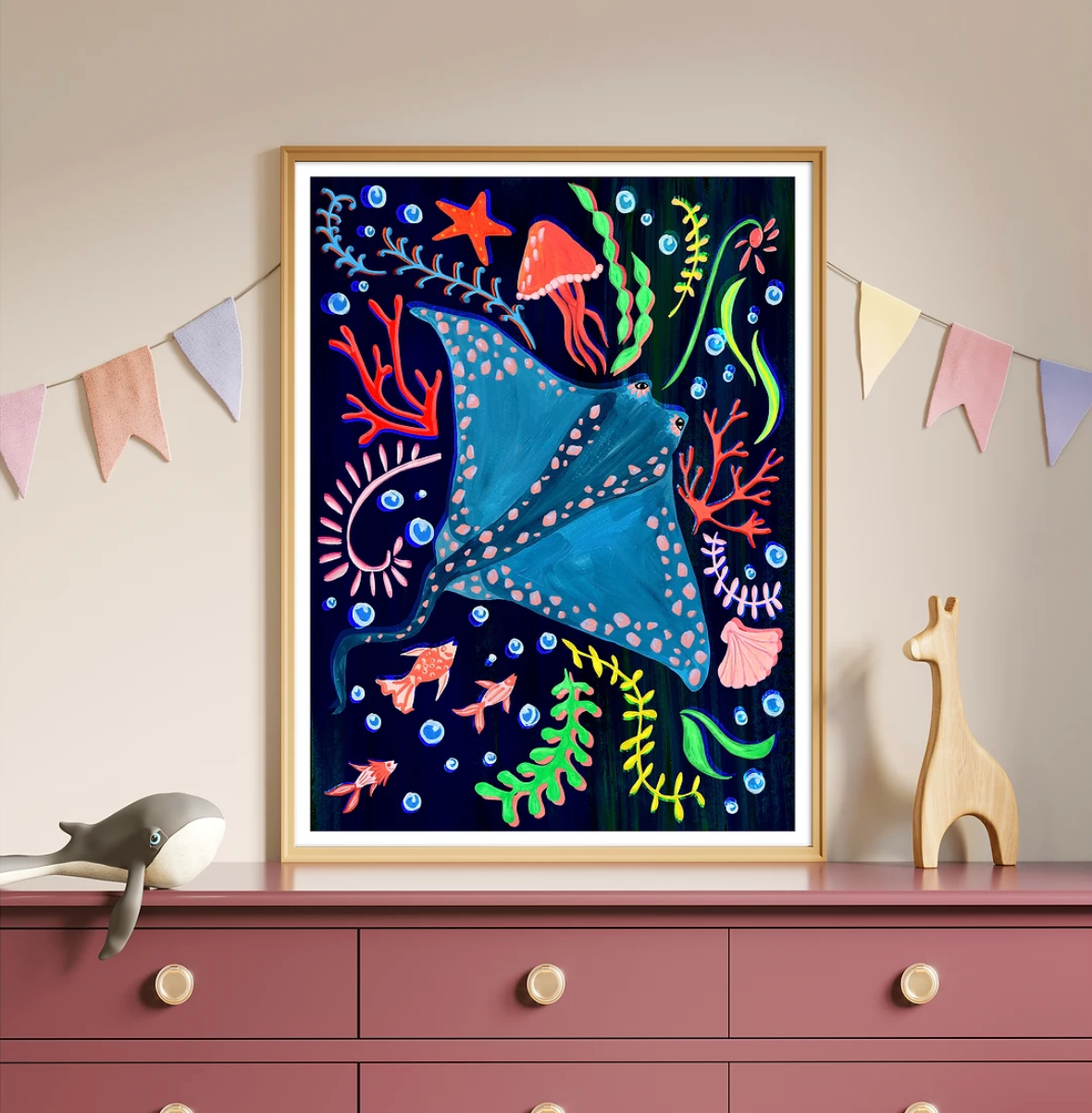 Colorful framed artwork of a stingray and underwater scene on a wall above a dresser.