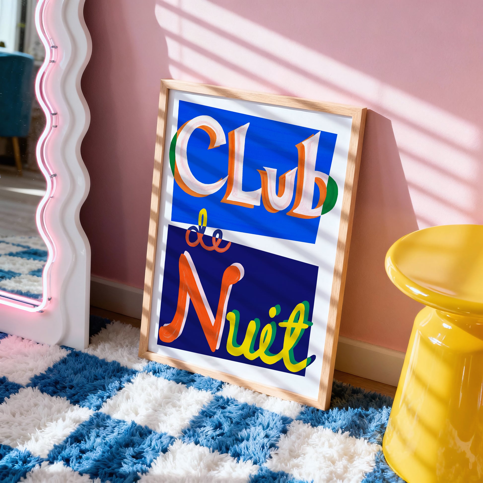 Framed artwork with 'Club de Nuit' text on a checkered floor with a yellow stool and pink wall.