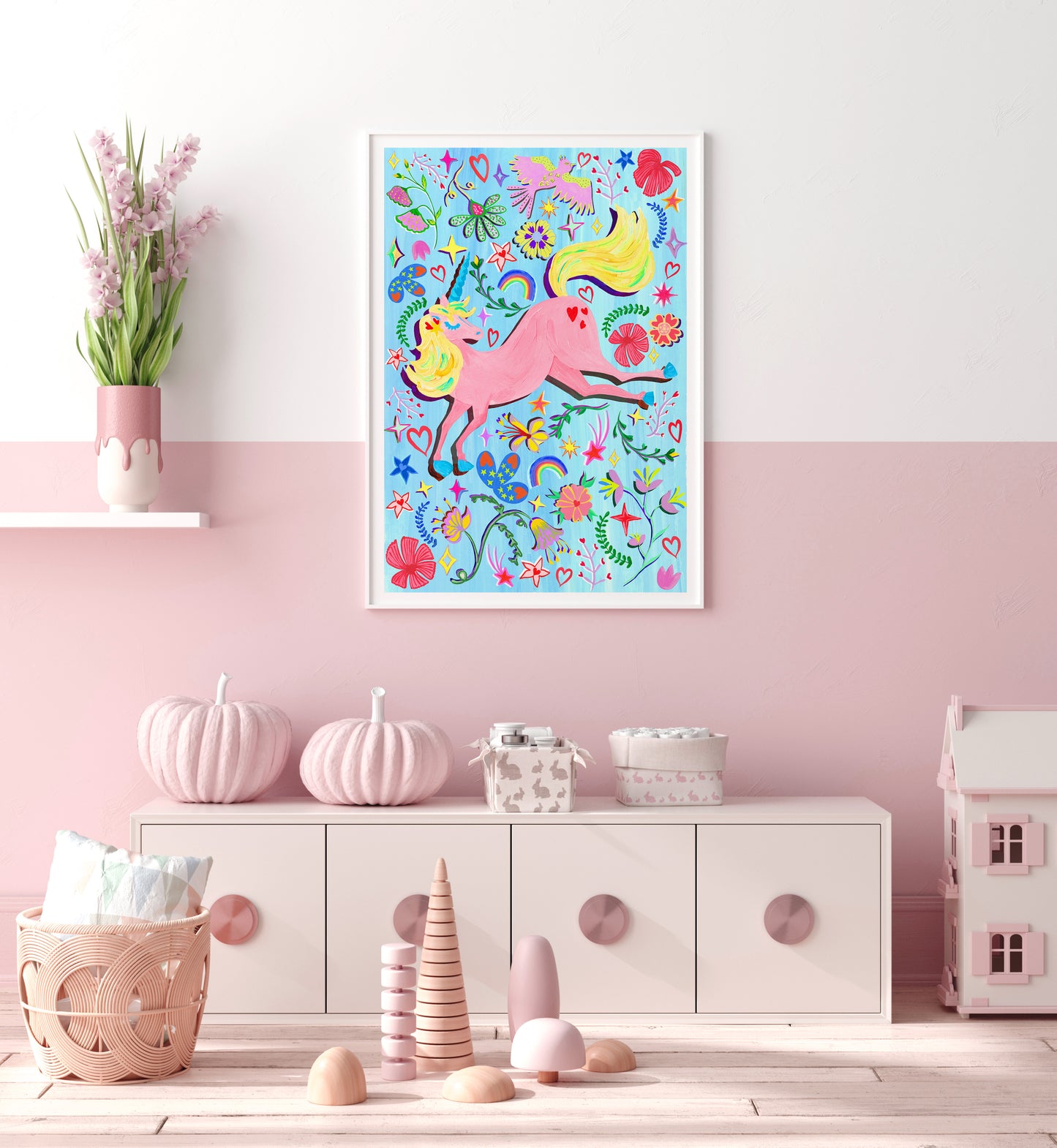 A pink nursery with a colourful unicorn print with a blue background