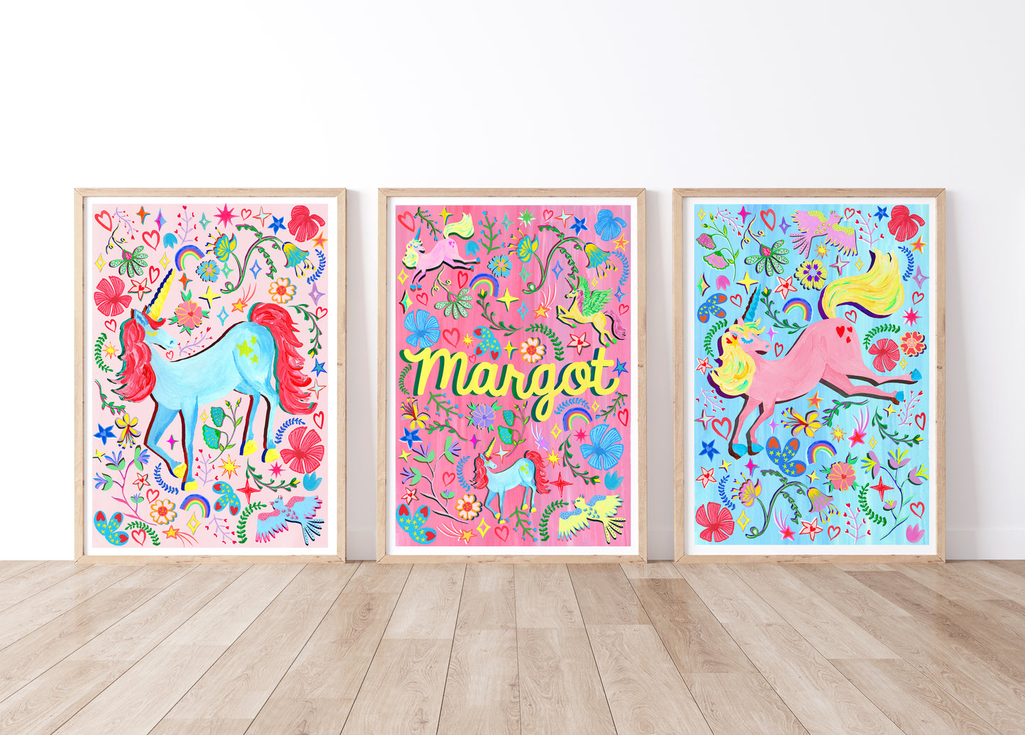 Three colorful unicorn prints with floral designs on a white wall.