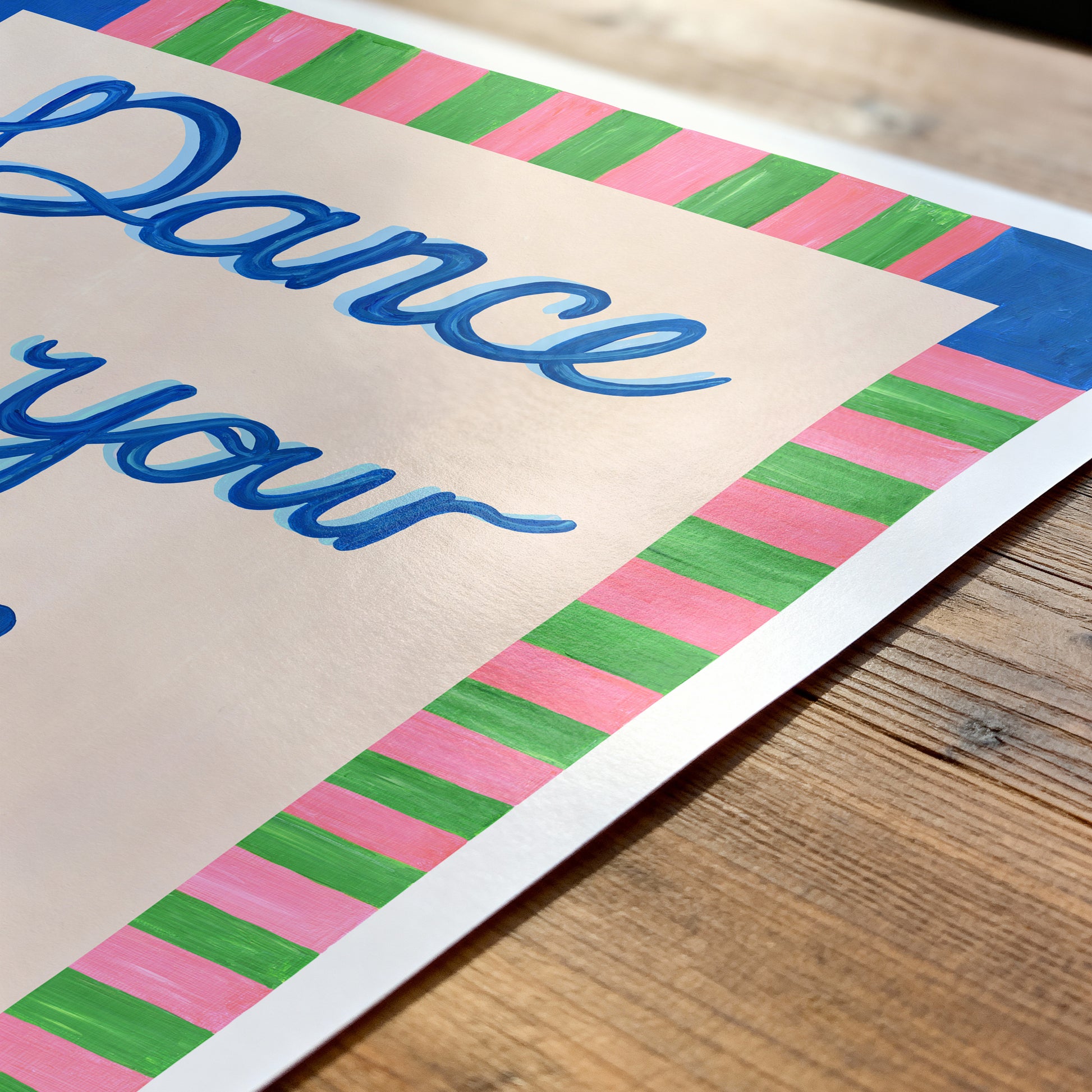 Colorful sign with 'Dance your' text on a wooden surface