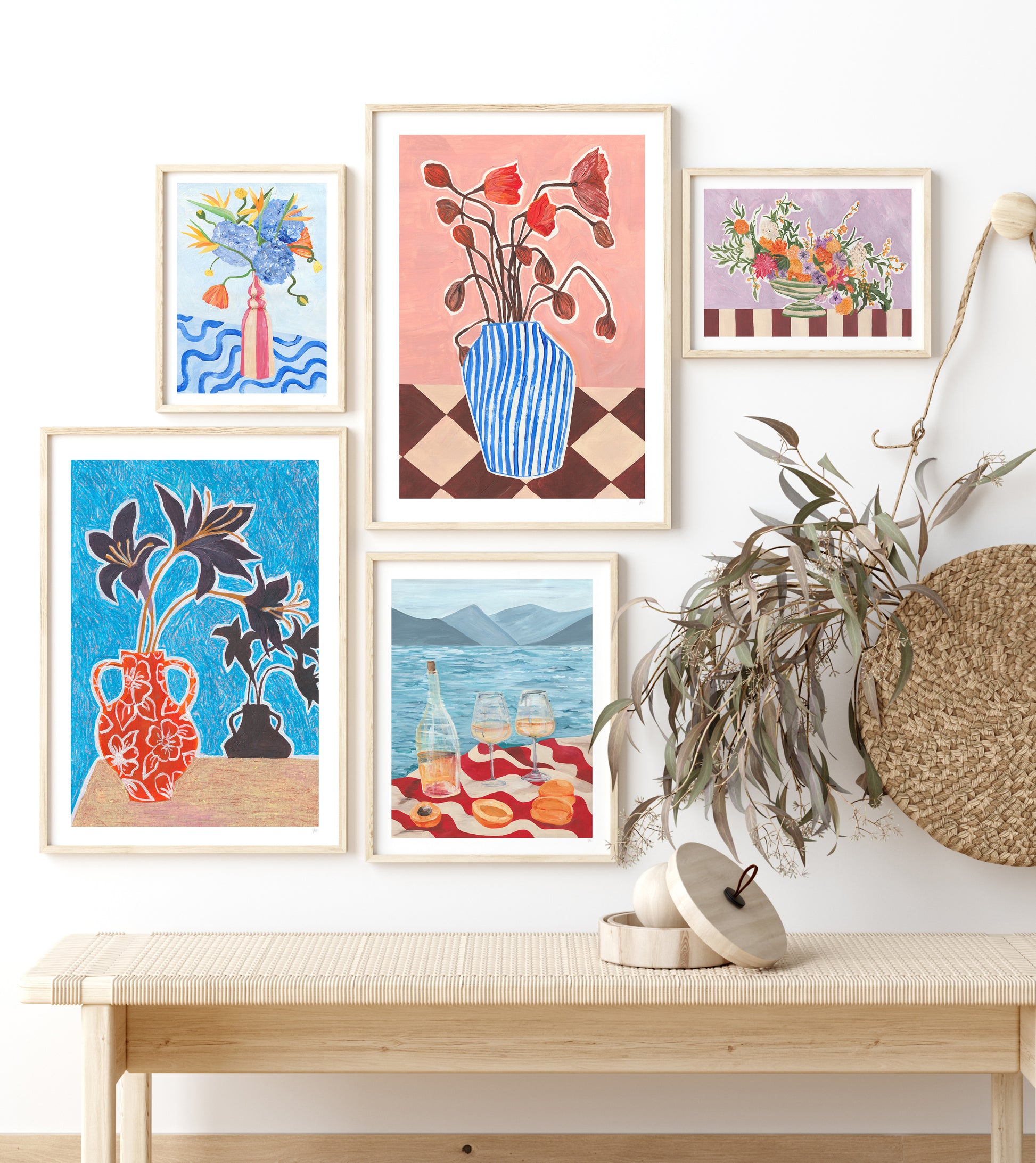 Wall with framed floral artworks and a wooden bench
