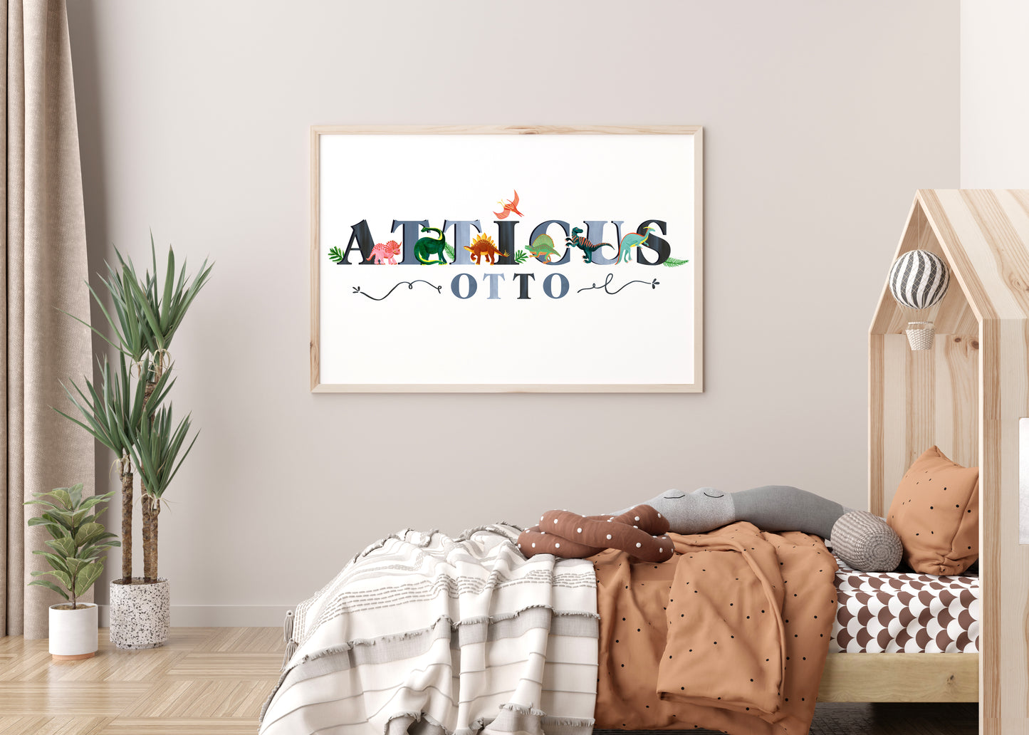 Children's room with a framed dinosaur illustrated name artwork on the wall, bed with pillows, and plants.