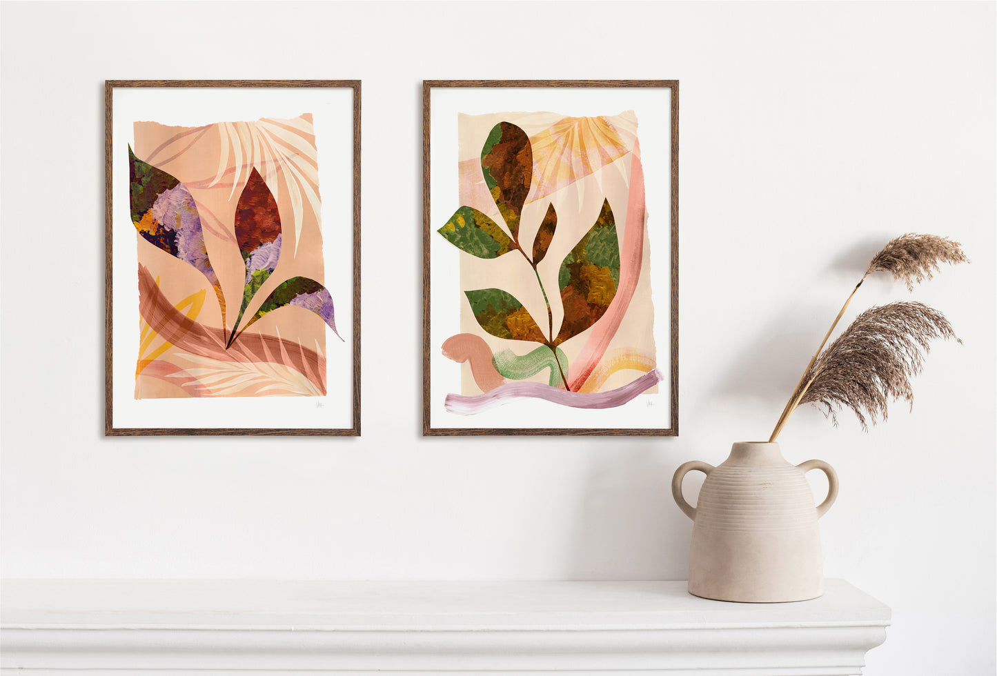 Two framed abstract leaf artworks on a white wall with a vase and dried plants.