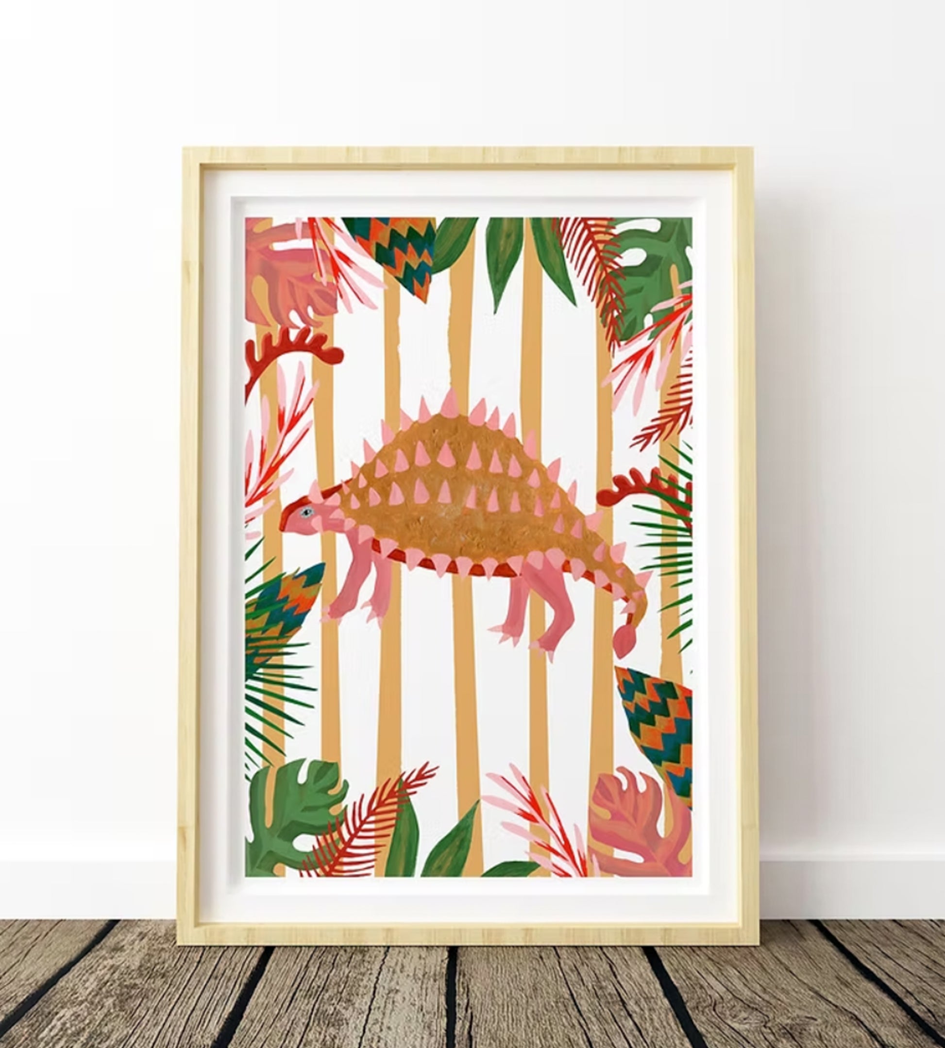 An illustration of an Emontonia Dinosaur with a striped background and colourful tropical leaf boarder in a light wood frame