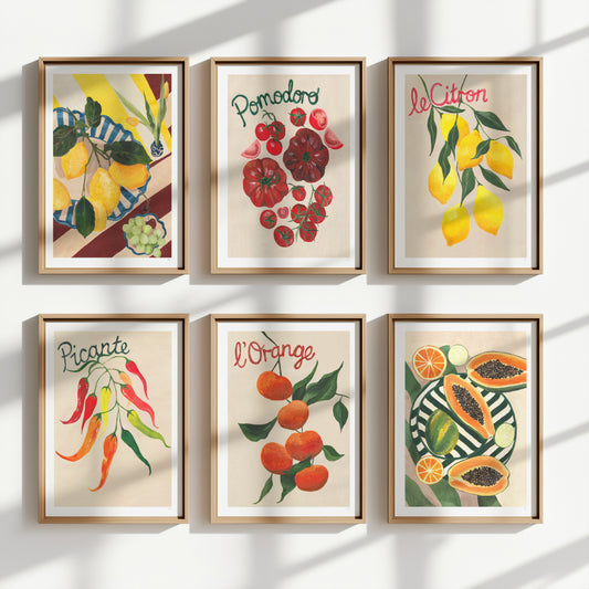 Set of six framed fruit prints on a white wall.
