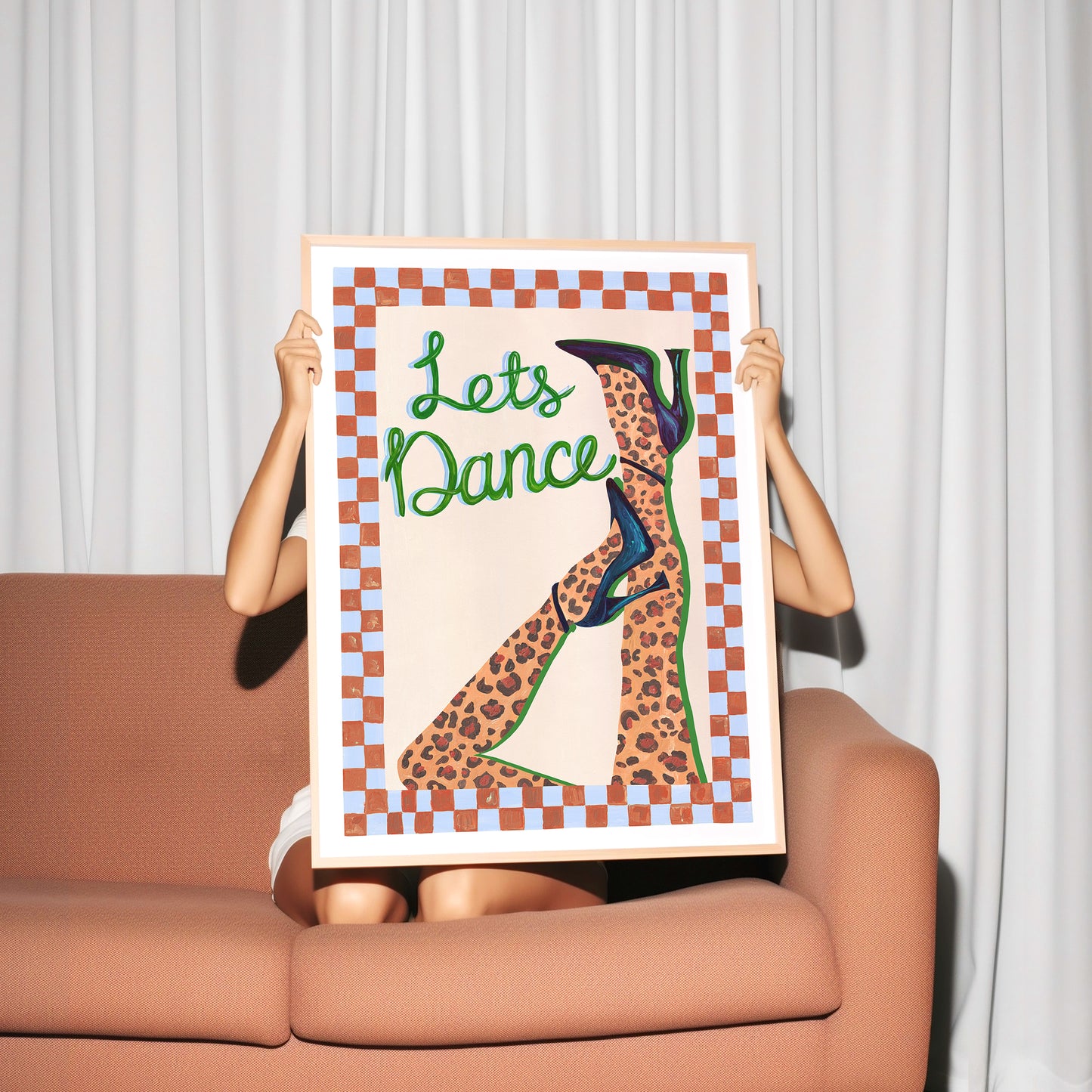 Person holding a framed artwork with 'Let's Dance' text and leopard print design.