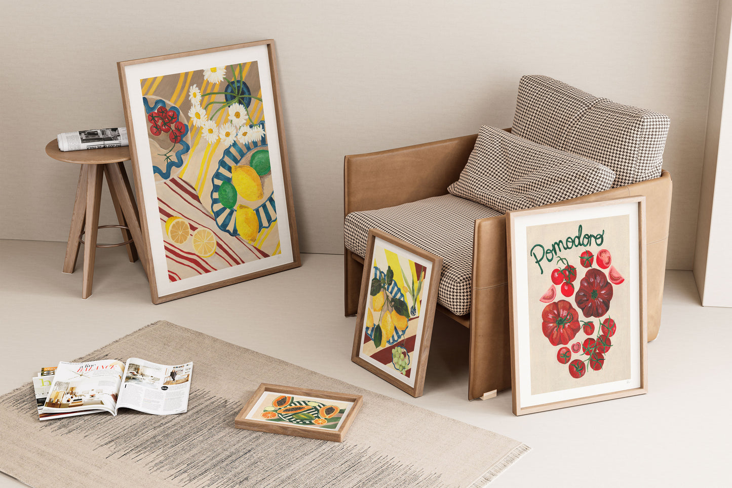 Framed artworks on a floor with a chair and small table in the background