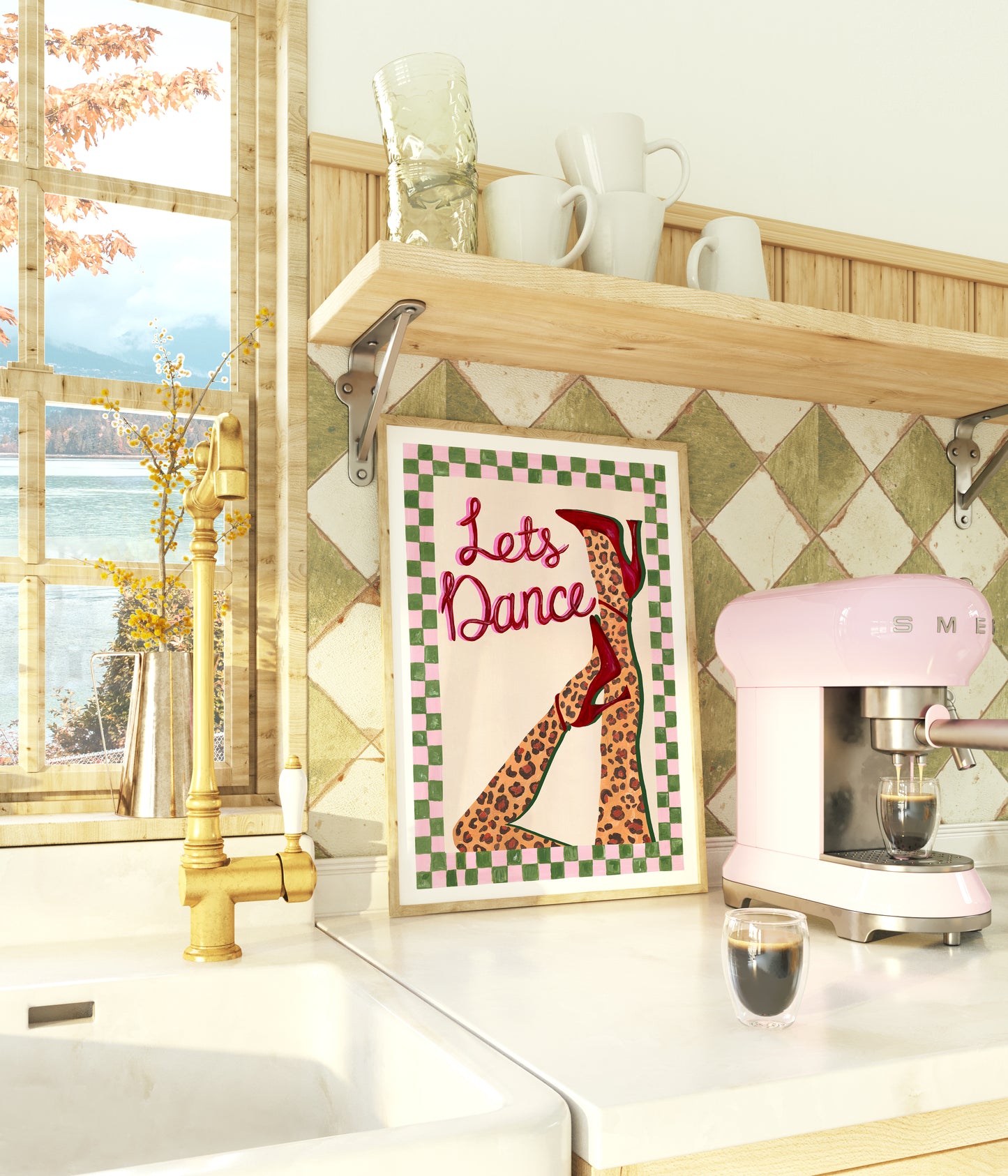 Kitchen counter with a pink Smeg mixer, framed artwork, and window view.