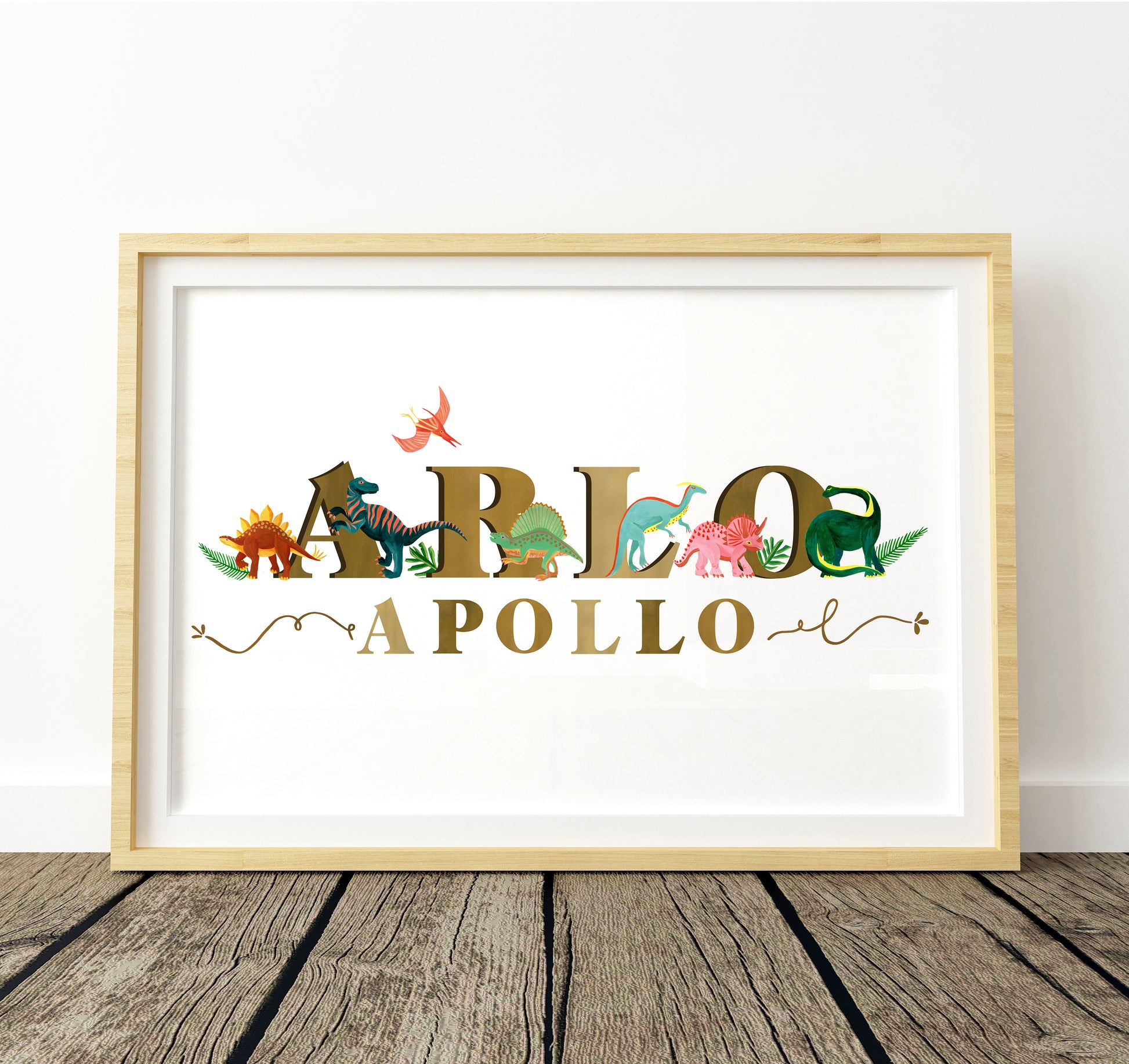Framed artwork with colorful dinosaur-themed letters spelling 'Apollo' on a white background.