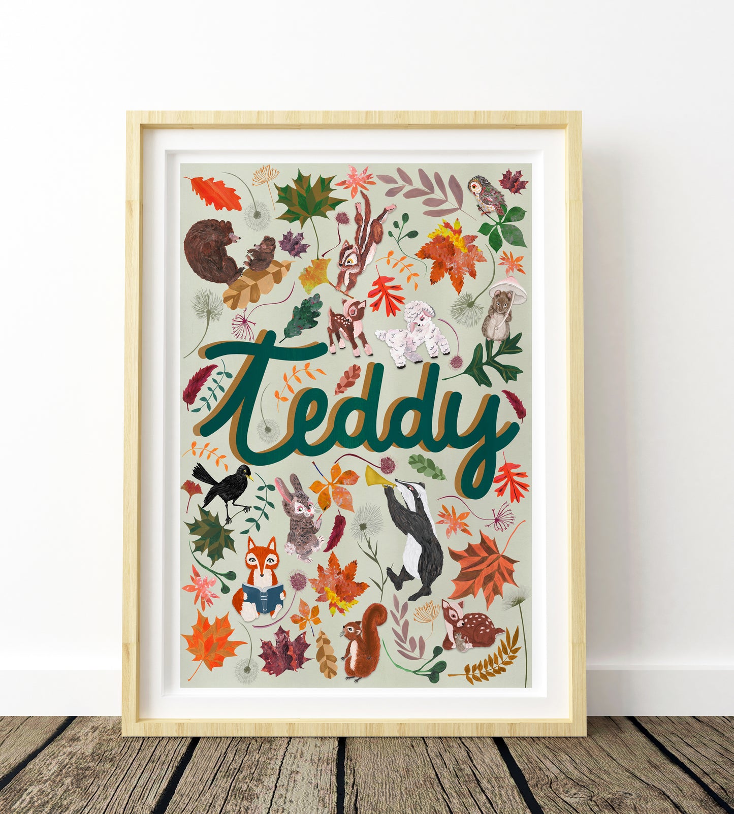Framed artwork with 'Teddy' and various animals and leaves on a white wall.
