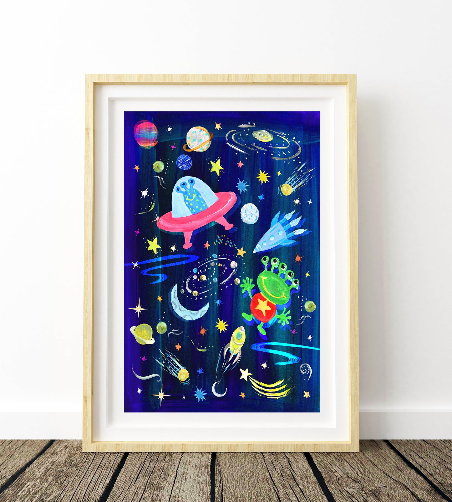 Framed artwork with space-themed design featuring planets, stars, and a rocket on a blue background.