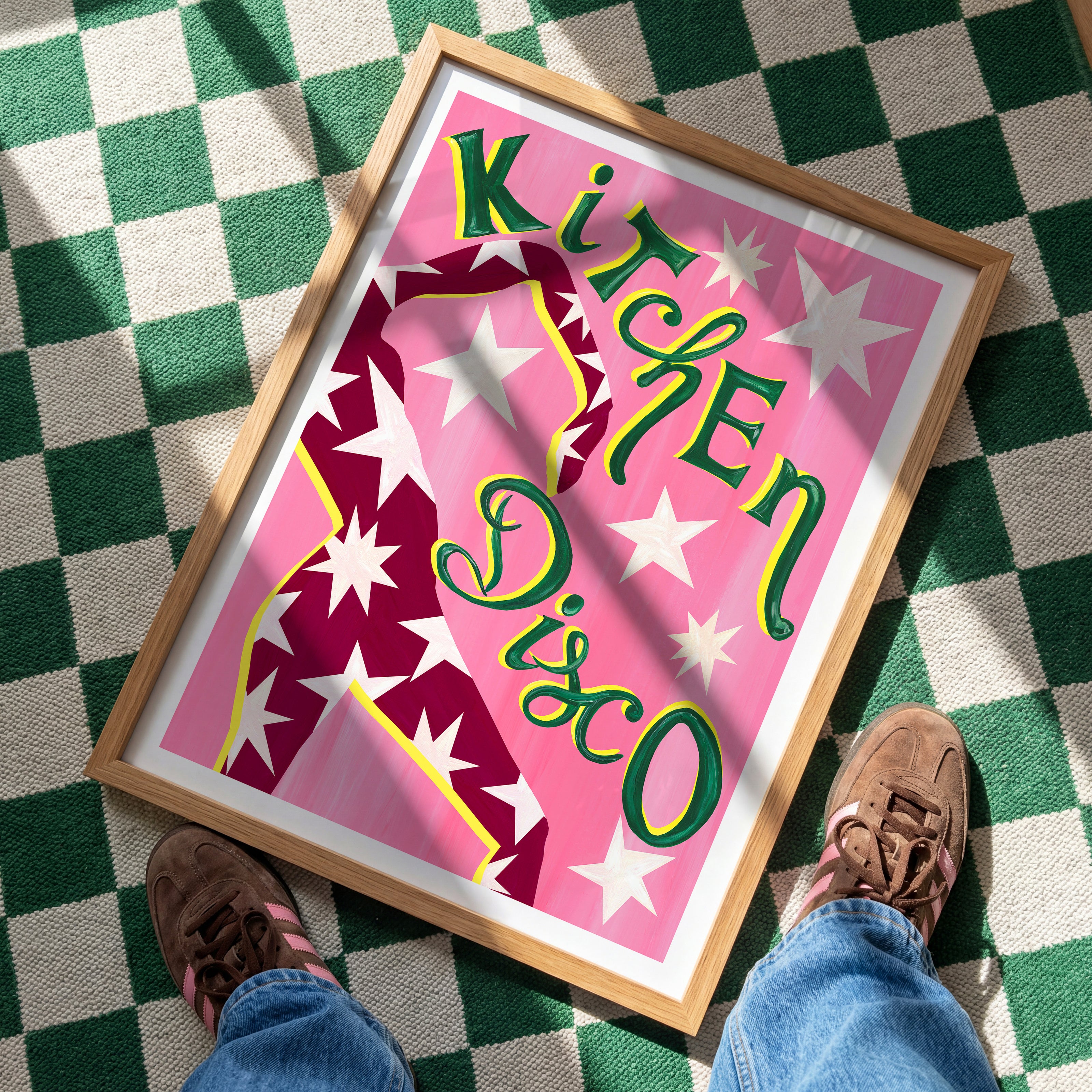 Framed 'Kitchen Disco' poster on a checkered floor with shoes visible