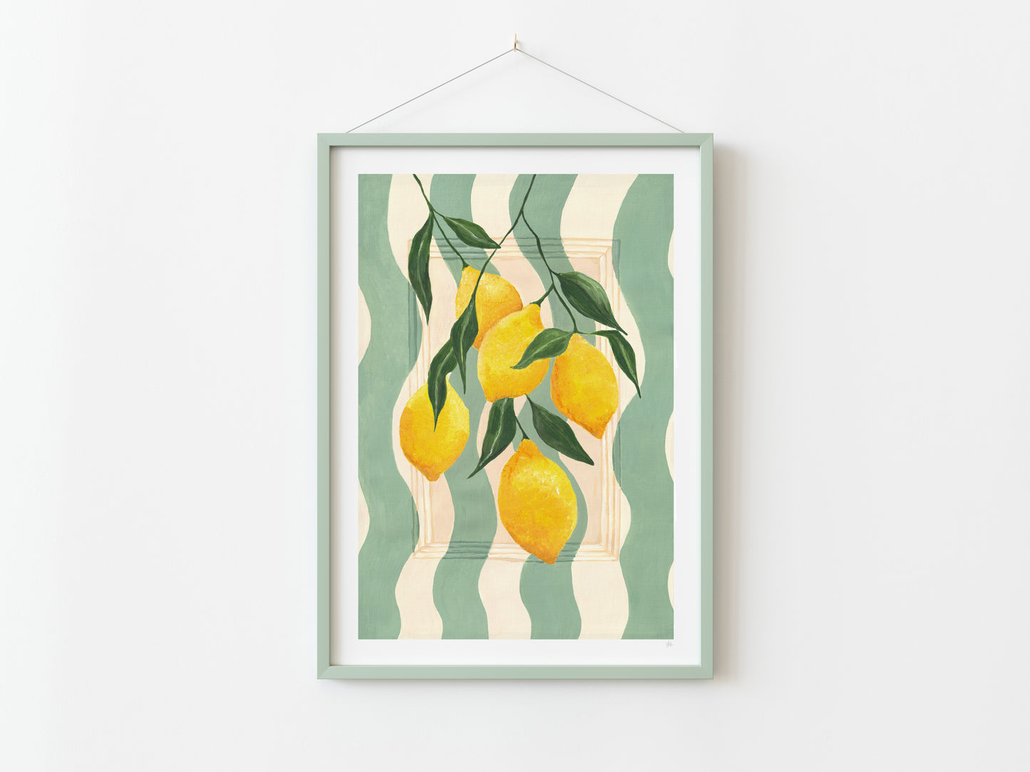 Framed artwork with lemons and leaves on a striped background, hanging on a white wall.