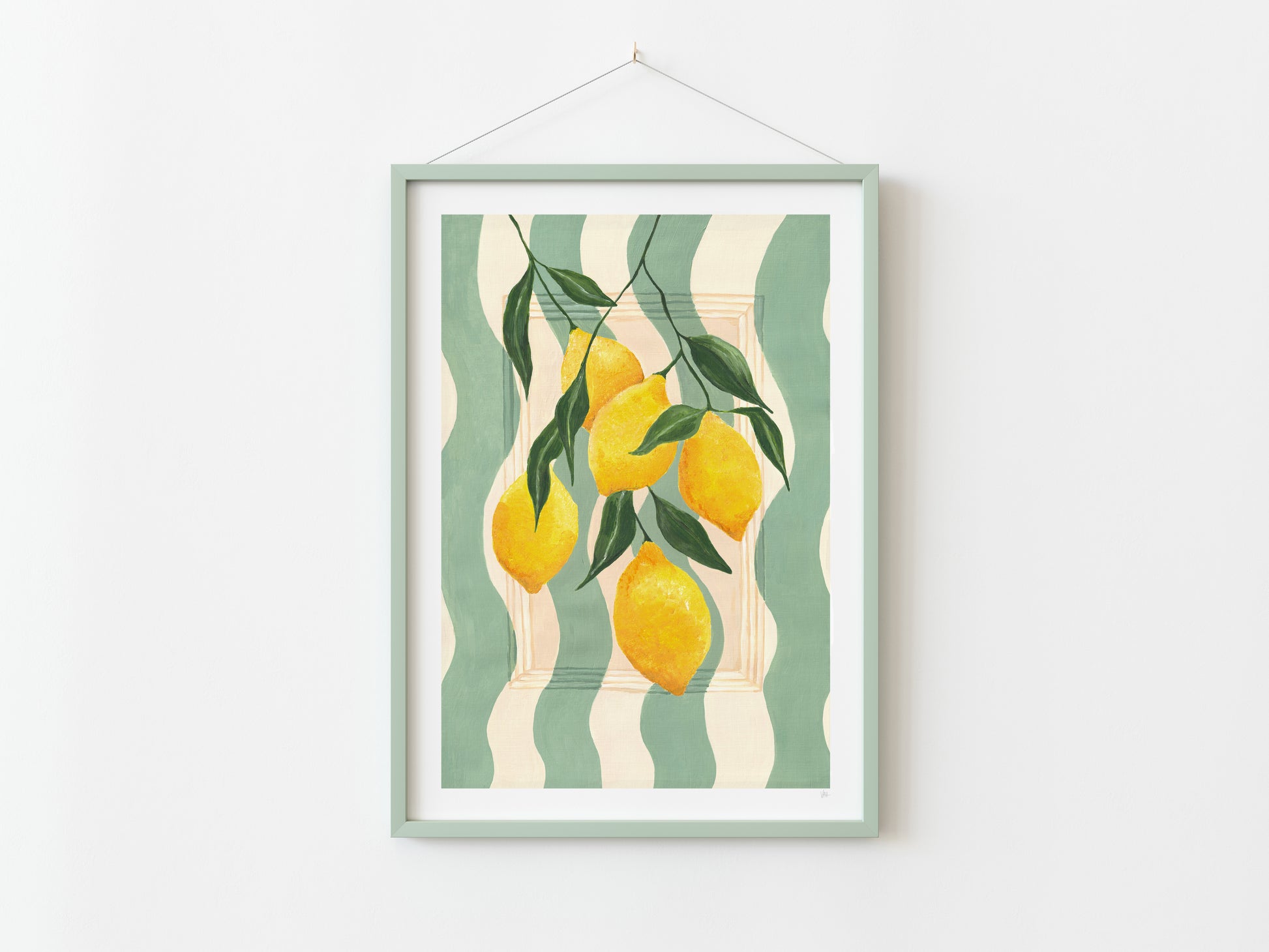 Framed artwork with lemons and leaves on a striped background, hanging on a white wall.