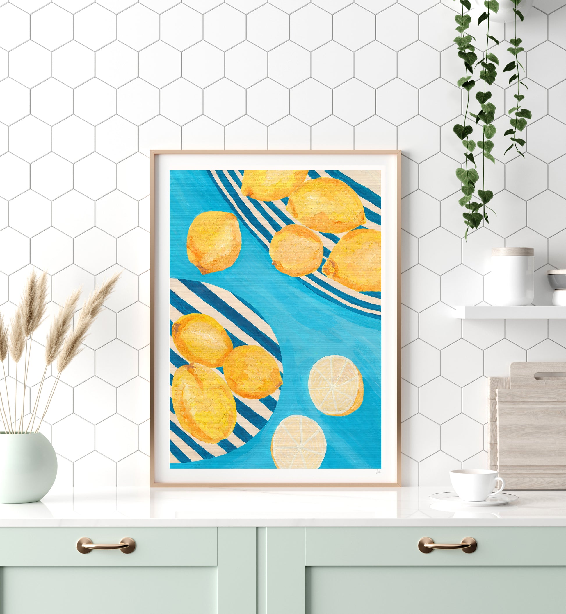 Framed artwork of lemons on a blue background in a kitchen setting.