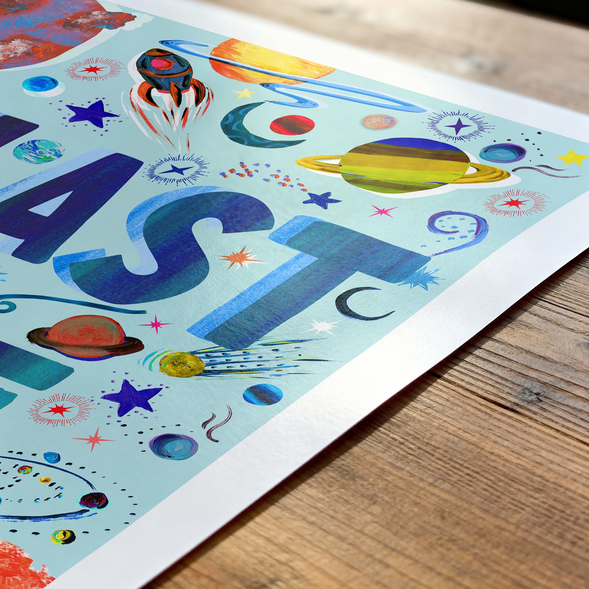 Colorful children's poster with space-themed letters on a wooden surface