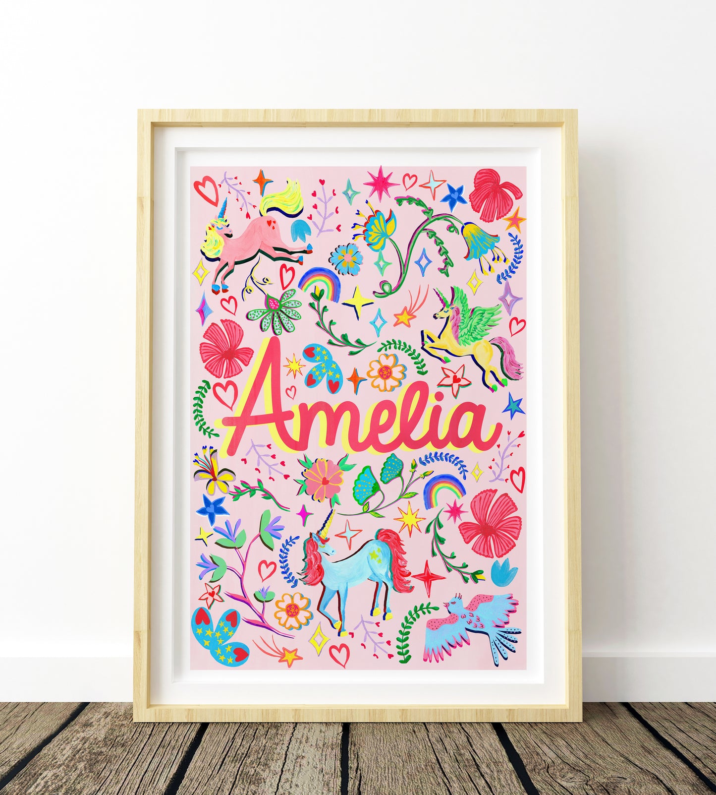 Colorful children's artwork with the name 'Amelia' framed on a white wall.